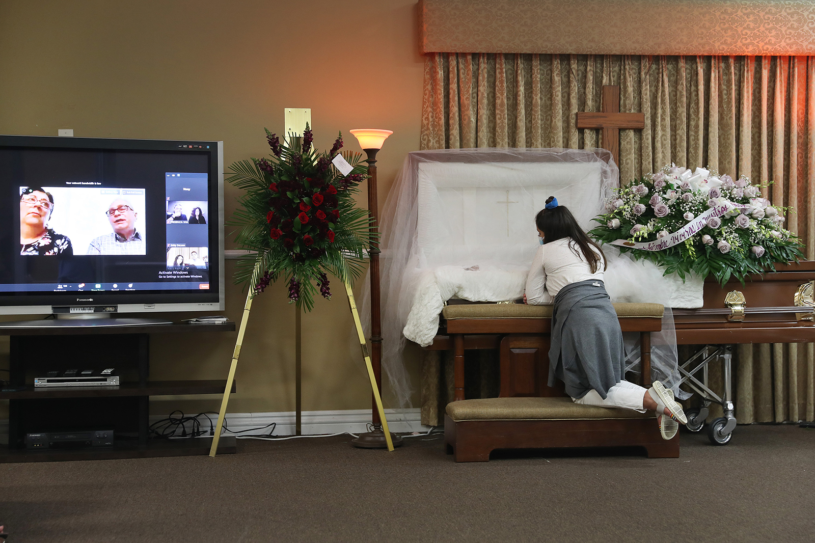 Asare Amaya,10 mourns for her father, German Amaya as family and friends are seen via a Zoom broadcast as they mourn together during the wake ceremony at the Maspons Funeral Home on August 8 in Miami, Florida.