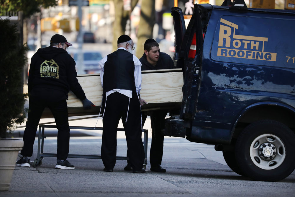 A casket is placed into a van outside of a funeral home in the heavily Orthodox Borough Park neighborhood of Brooklyn, which has scene a large number of deaths due to the coronavirus, on April 19, in New York City.