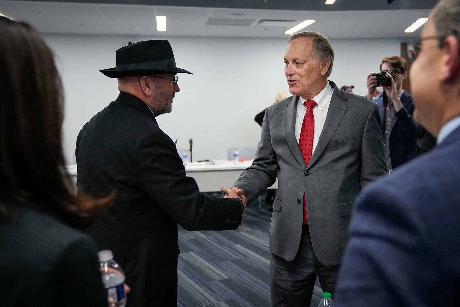 Rep. Clay Higgins shakes hands with Rep. Andy Biggs during a forum on November 14 in Washington, DC. 