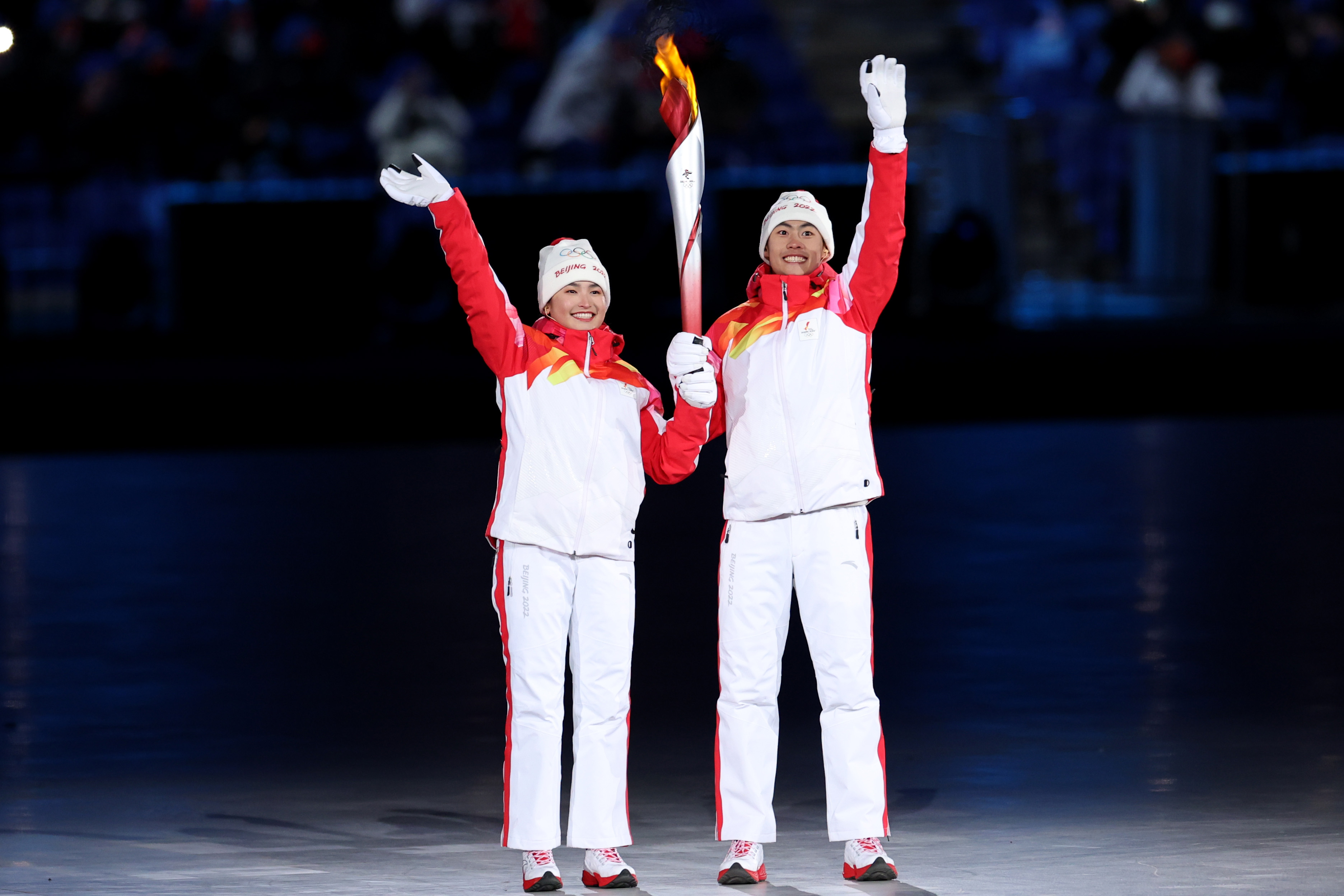 Torch bearers Dinigeer Yilamujiang and Jiawen Zhao of Team China hold the Olympic flame during the Opening Ceremony of the Beijing 2022 Winter Olympics at the Beijing National Stadium on February 04 in Beijing, China. 