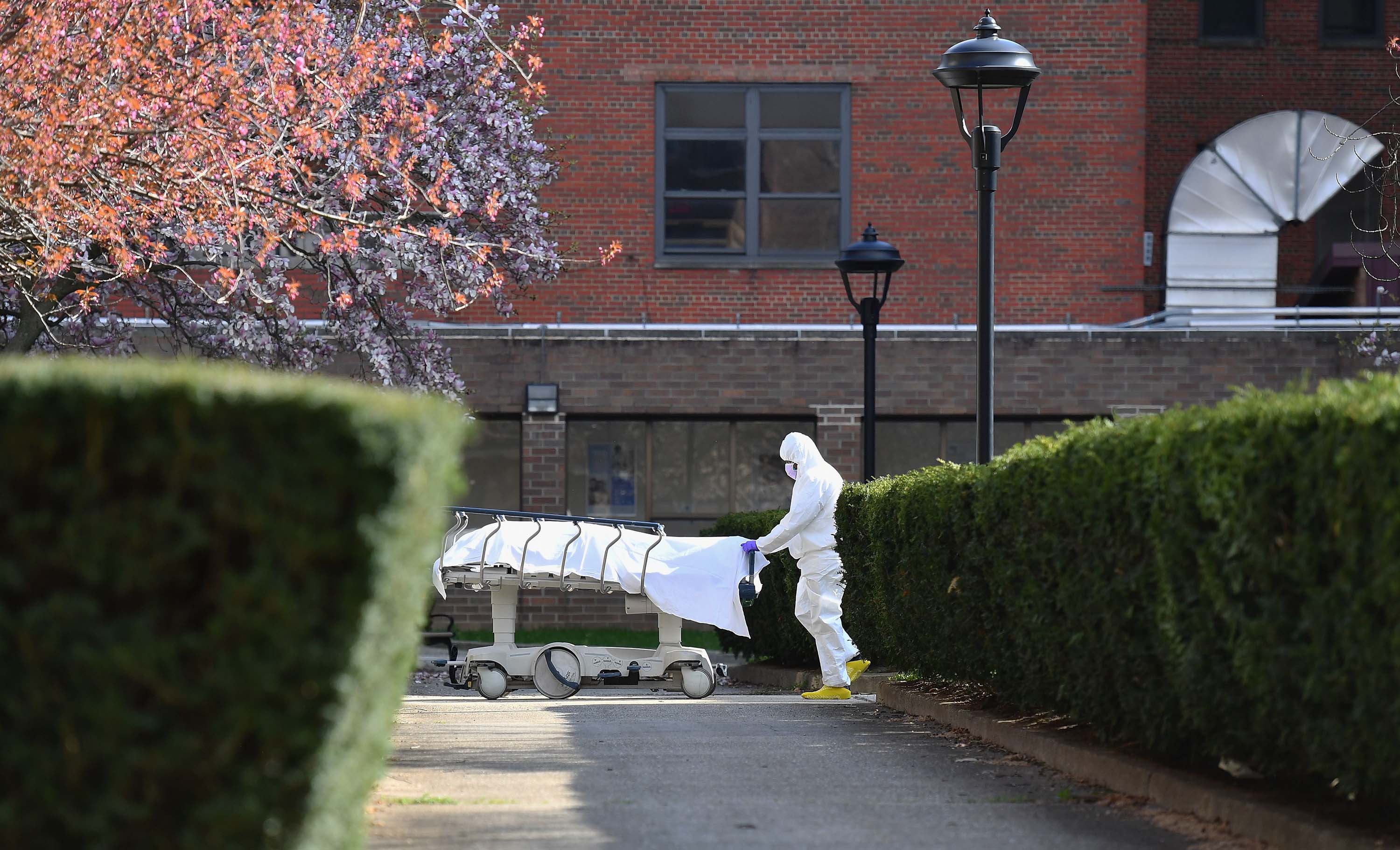 Medical personnel transport the body of a deceased coronavirus patient in Brooklyn, New York, on April 8.