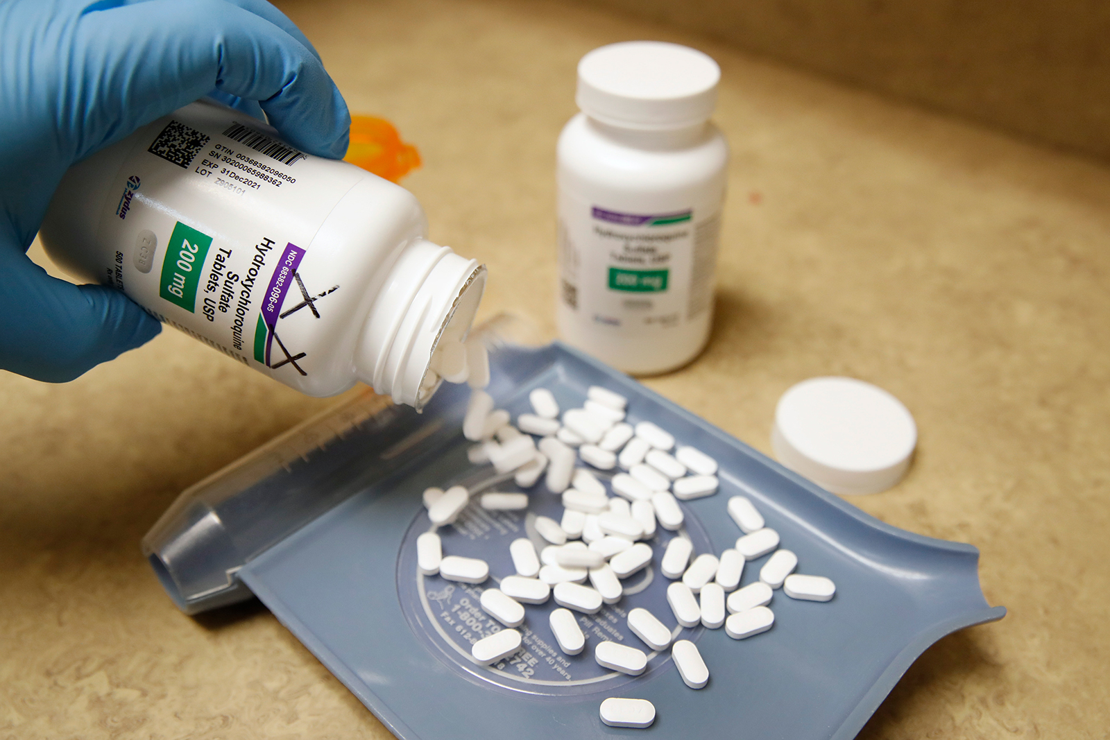 A pharmacy tech pours out pills of hydroxychloroquine at Rock Canyon Pharmacy in Provo, Utah, on May 20.