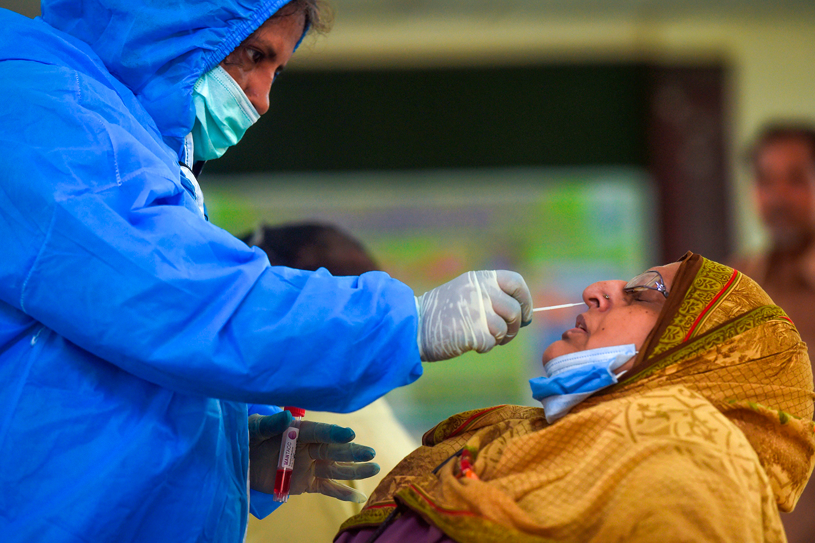 A health official collects a swab sample from a woman to test for Covid-19 in Karachi, Pakistan on September 14.