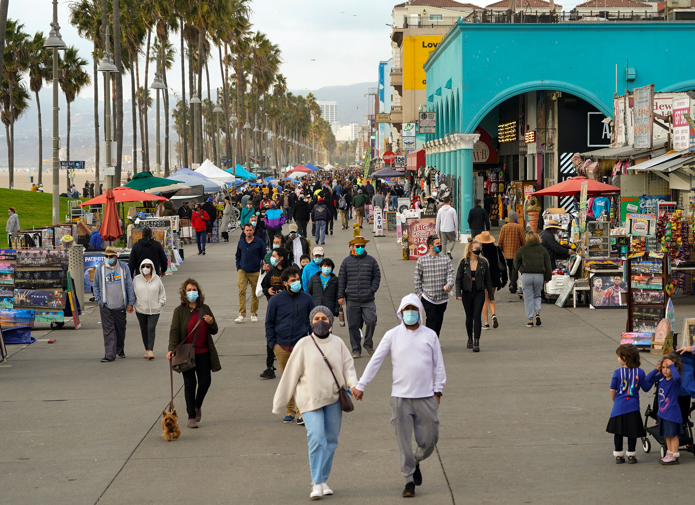 People walk along the Venice Beach Boardwalk on December 27 in Los Angeles, California. 