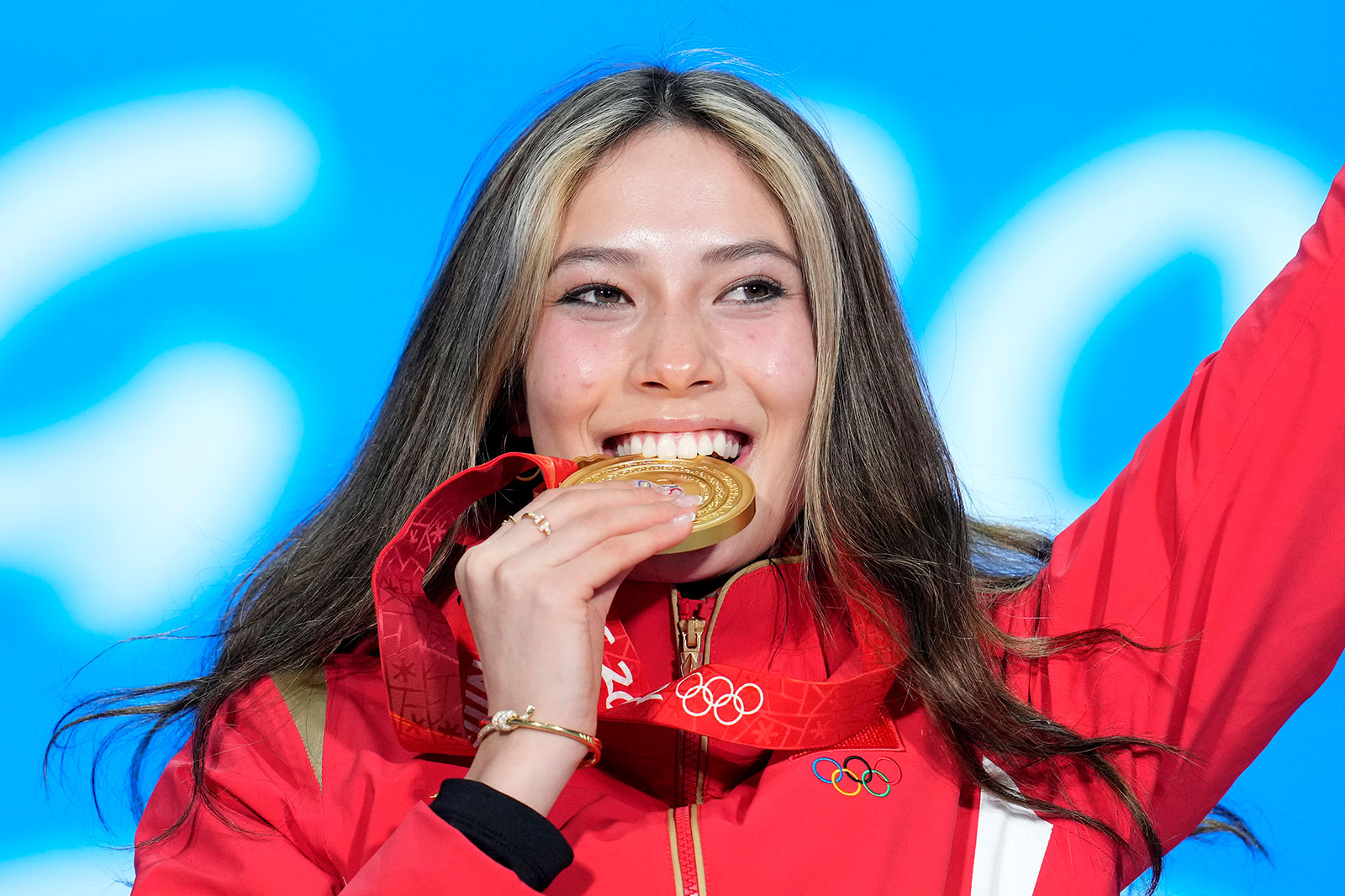 Chinese freestyle skier Eileen Gu bites her gold medal during the women's freeski big air medal ceremony on Tuesday.