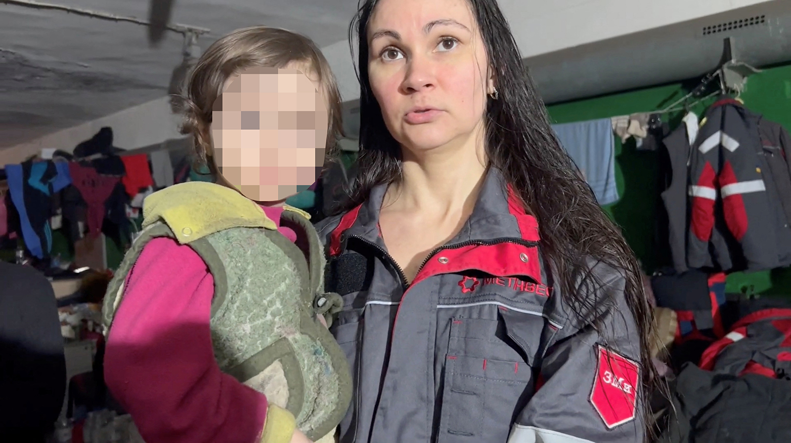 A woman holding a child speaks as they take shelter in a bunker of the Azovstal steelworks in Mariupol, Ukraine in this image released on April 23. A portion of this photo has been blurred by CNN to protect identity. 