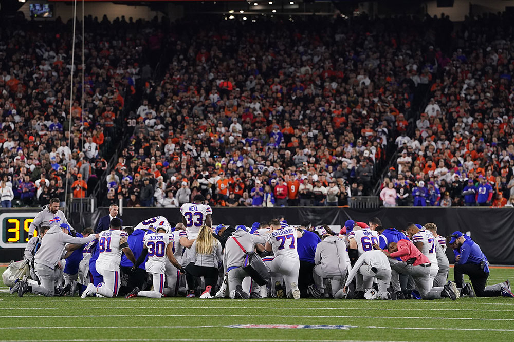 Bills players huddle and pray after Hamlin's collapse. 