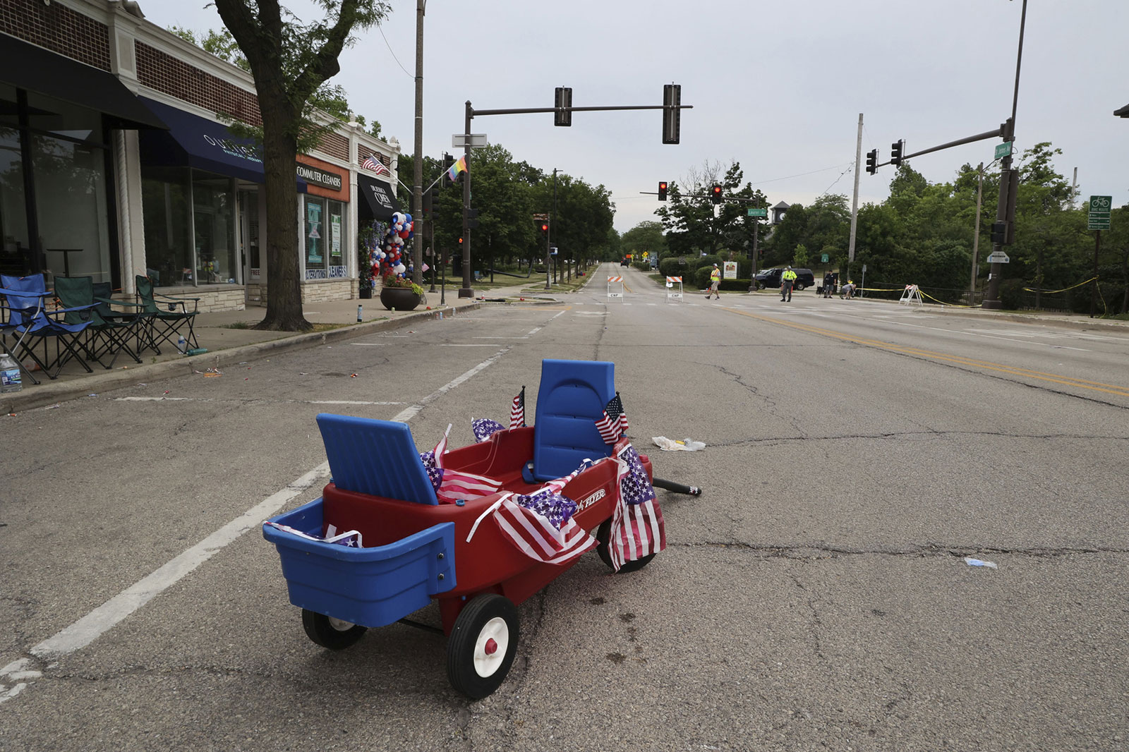 An empty wagon and American flags remain near the scene of the shooting in Highland Park, Illinois, on Monday, July 4.