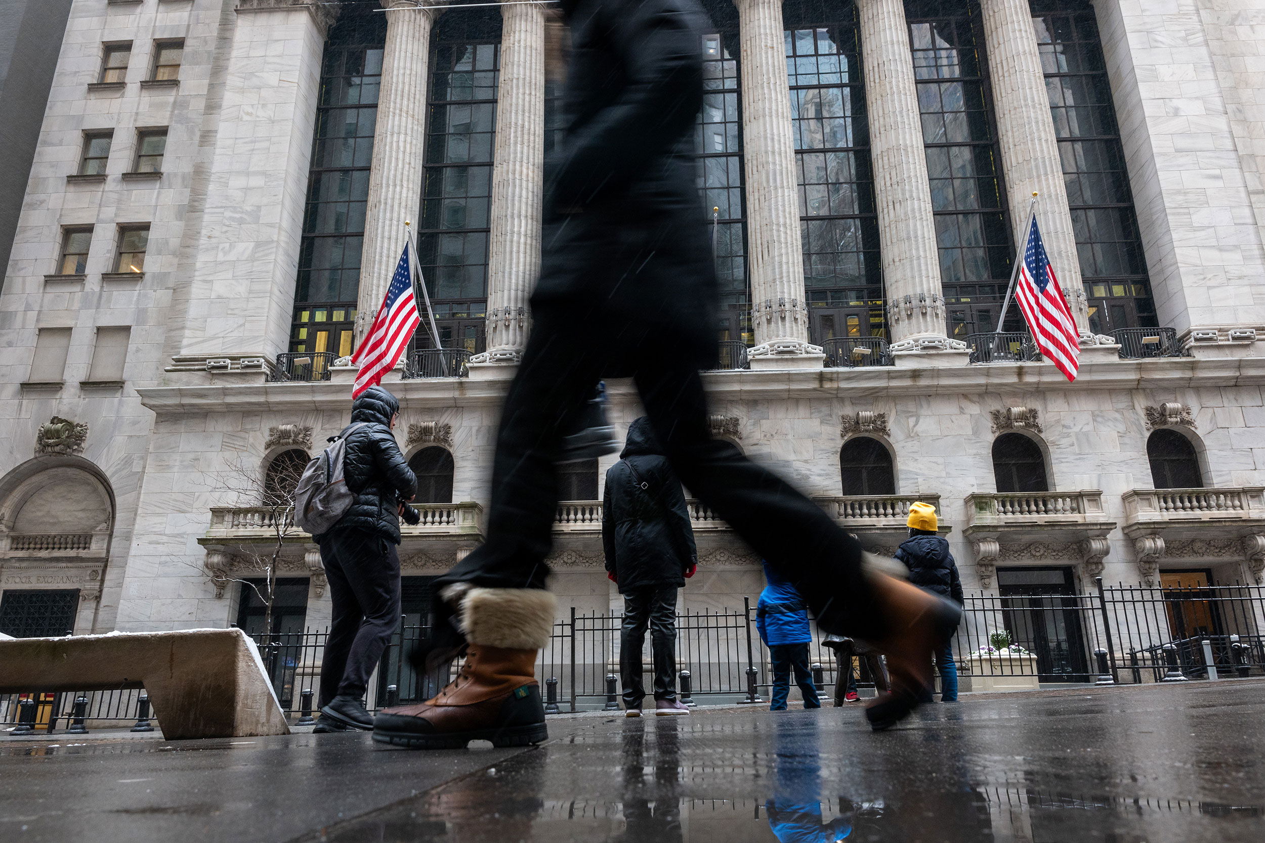 Pedestrians walk past the New York Stock Exchange on January 19.