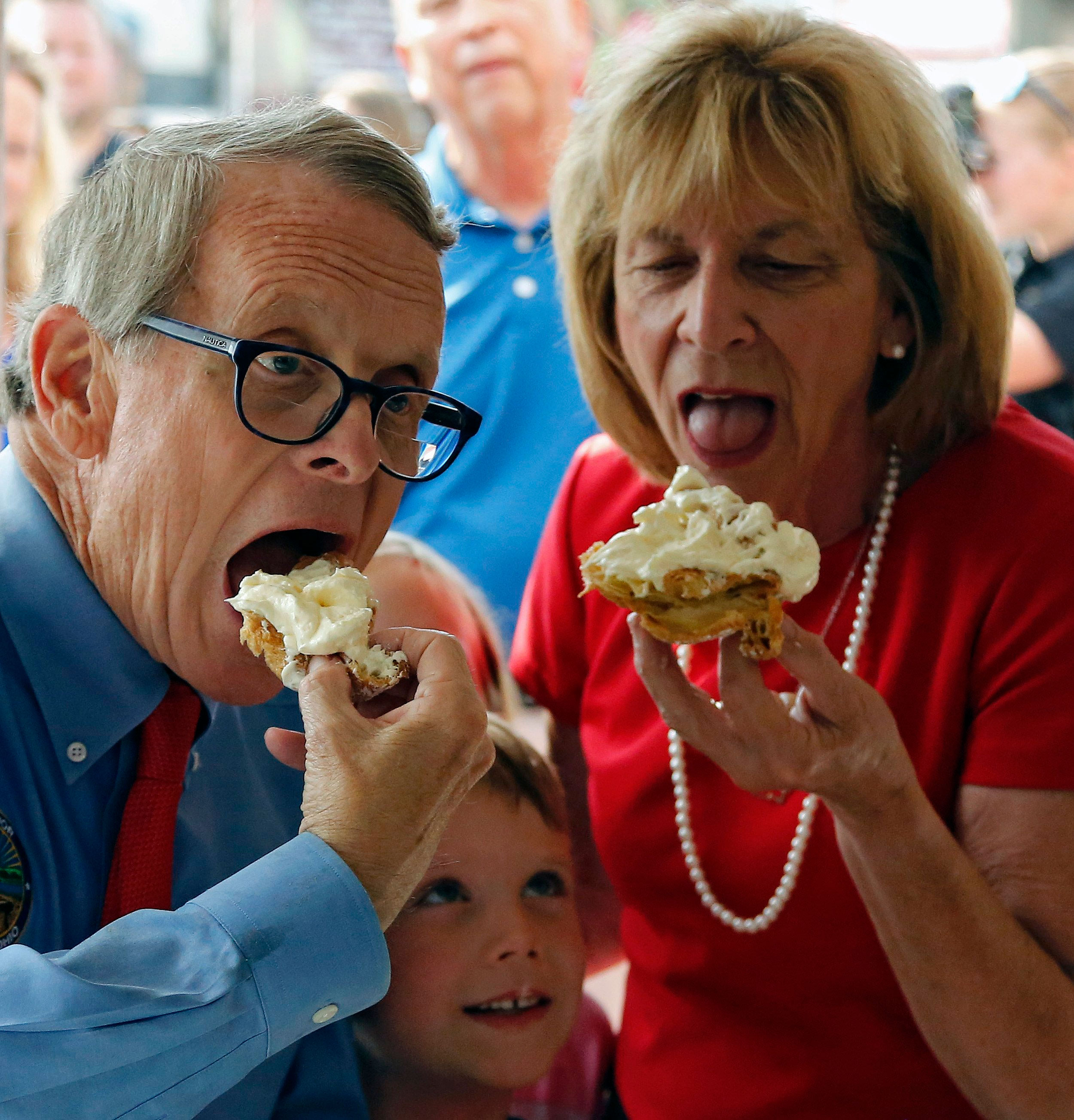 Ohio Gov. Mike DeWine and his wife Fran DeWine eat a cream puff at the Ohio State Fair in Columbus, Ohio, in 2019.