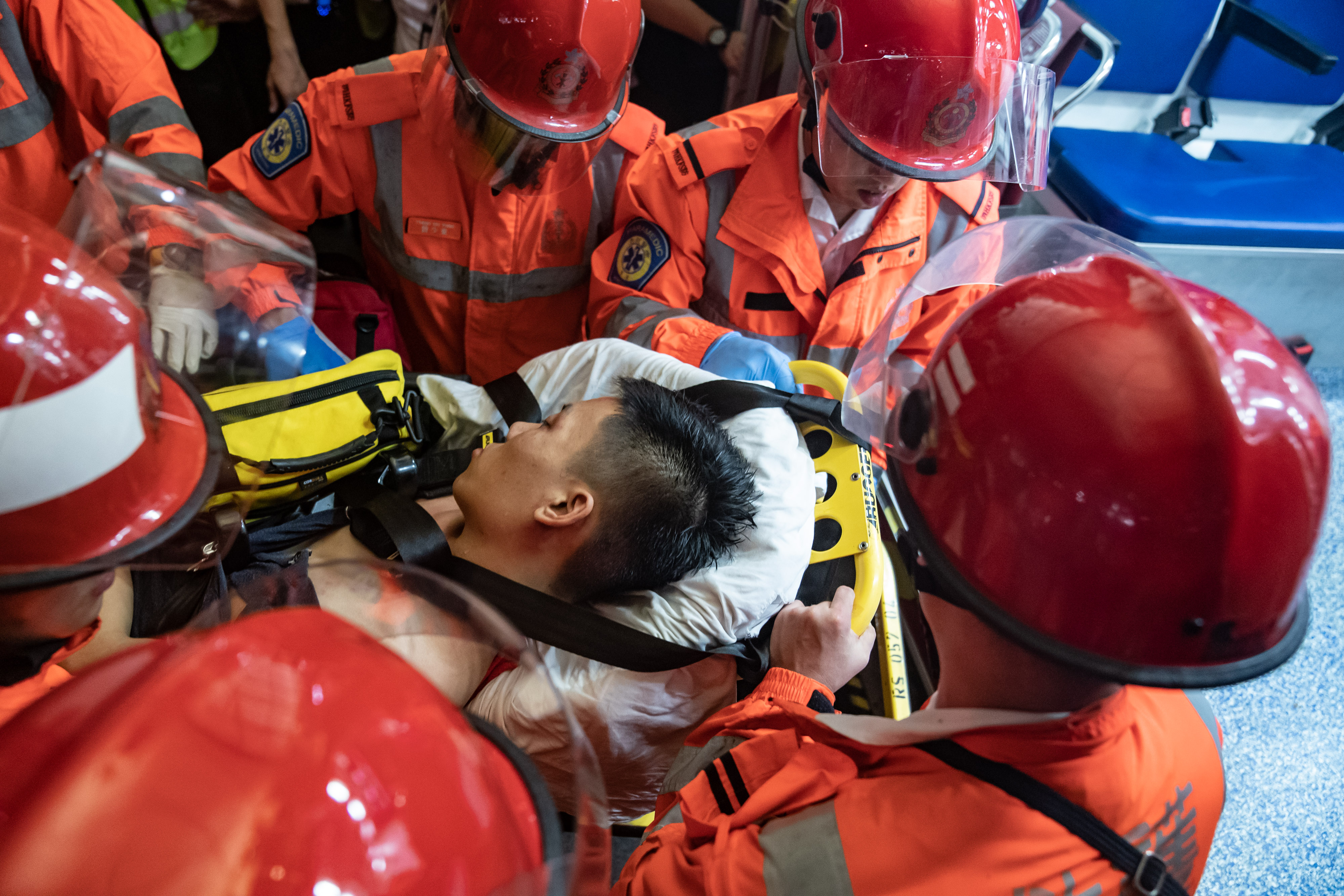 An injured man, who was suspected by protestors of being an undercover police officer, is taken away by paramedics at the Hong Kong International Airport during a demonstration on August 13, 2019.