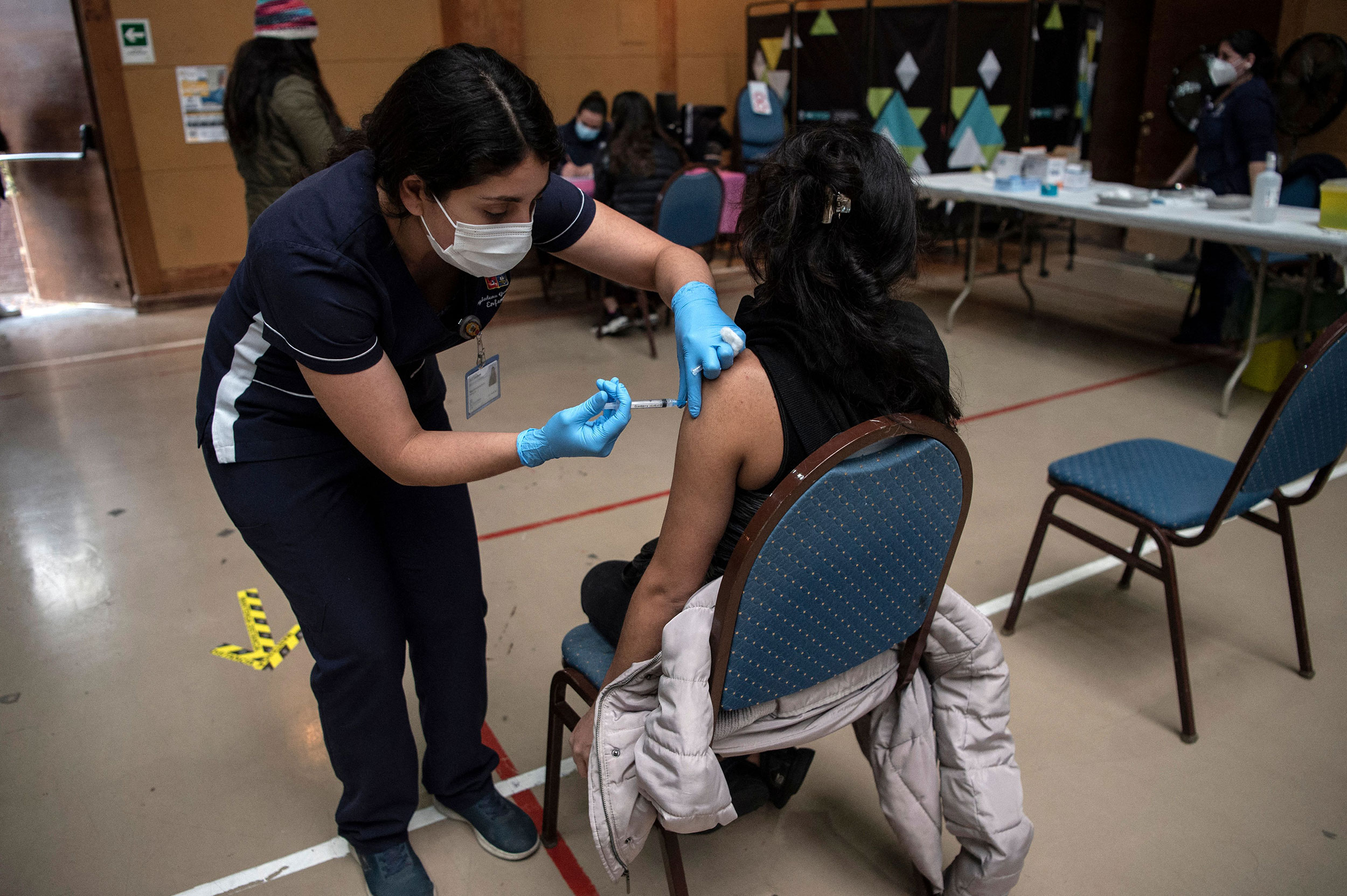 A health care worker administers a dose of a Covid-19 vaccine at a vaccination center in Santiago, Chile, in June.