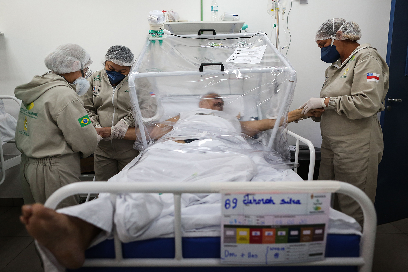 Health workers assist a COVID-19 patient at the Gilberto Novaes Municipal Hospital in Manaus, Brazil, on June 8.