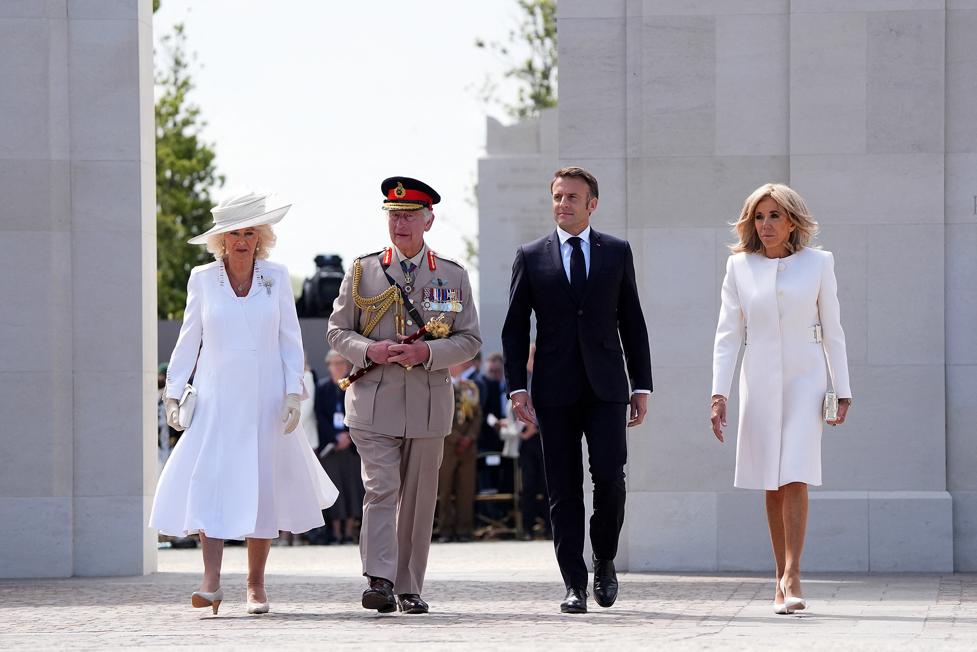 Britain's King Charles III and his wife Britain's Queen Camilla walk with France's President Emmanuel Macron and his wife Brigitte Macron as they pass the memorial wall during the ceremony marking the 80th anniversary of the World War II D-Day Allied landings near the village of Ver-sur-Mer, France, on June 6.