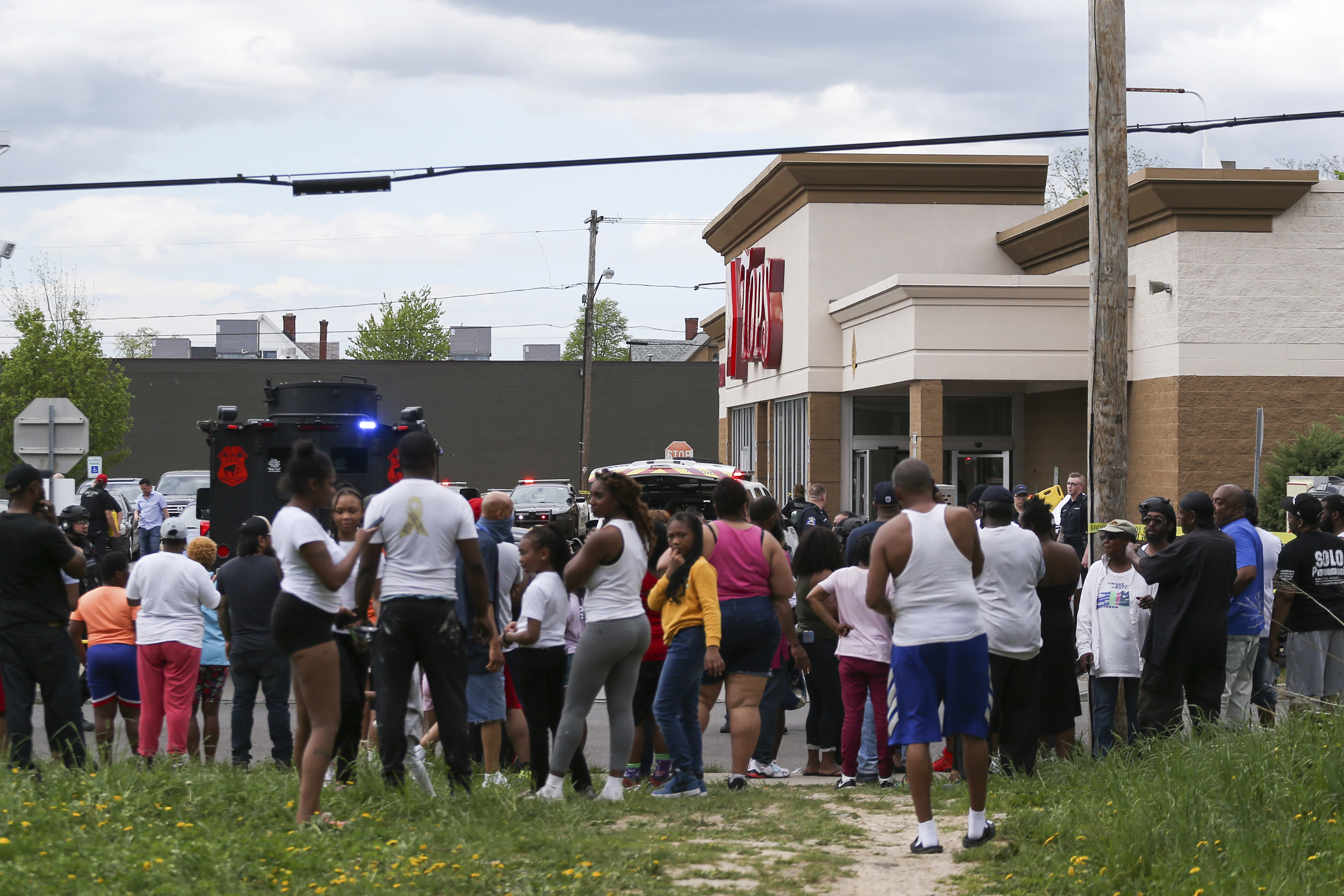 People gather as police investigate the mass shooting at a Buffalo supermarket.