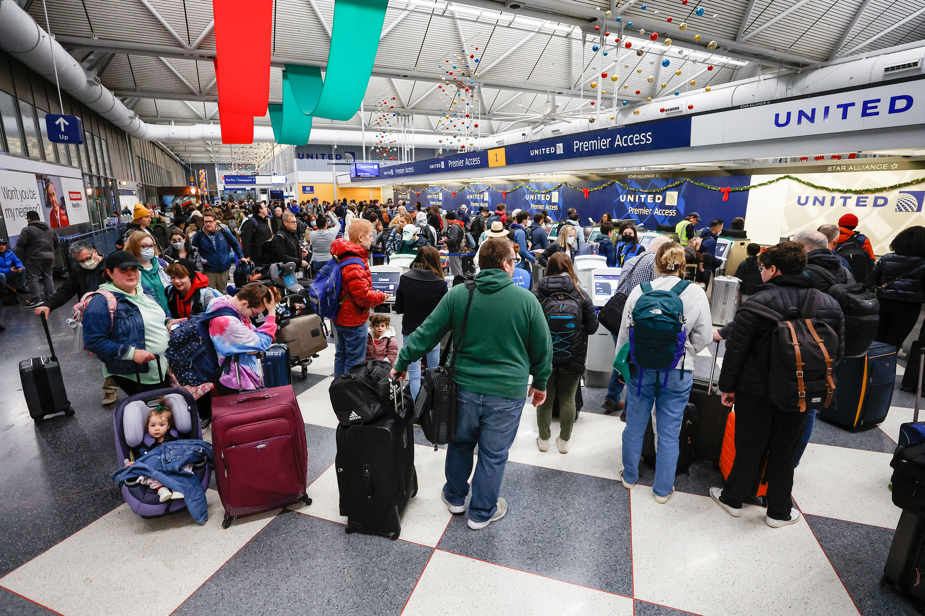 Travelers wait in line to check-in for their flights at the United Airlines Terminal 1 ahead of the Christmas Holiday at O'Hare International Airport on December 22, in Chicago.
