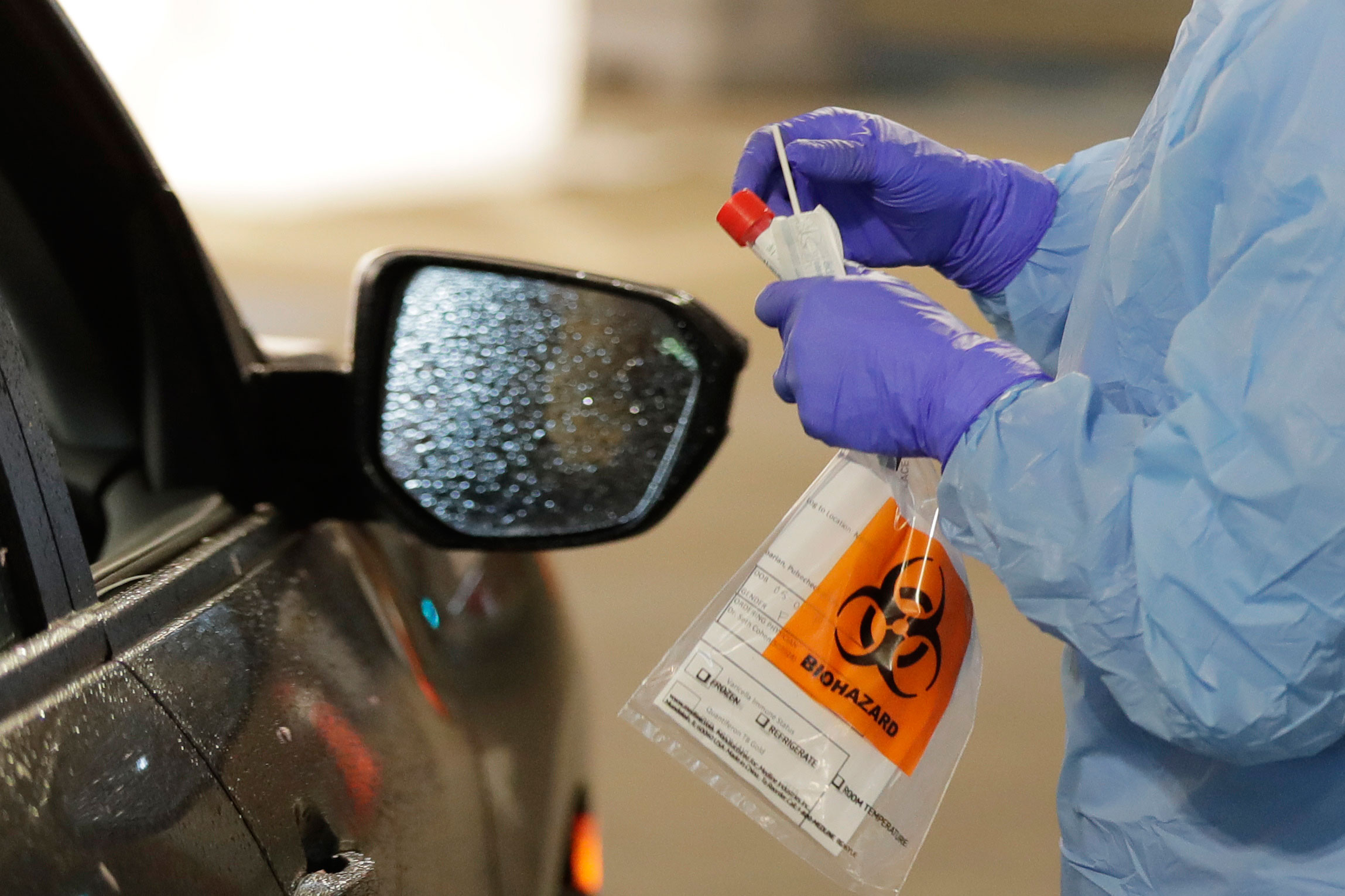 A nurse holds a swab to take a sample at a drive up coronavirus testing station at the University of Washington Medical Center in Seattle on March 13.