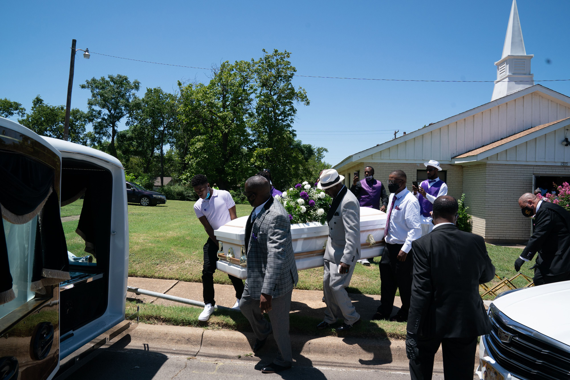 A casket carrying the body of Lola M. Simmons is placed into a hearse following the funeral service at the Denley Drive Missionary Baptist Church in Dallas, Texas on July 30.