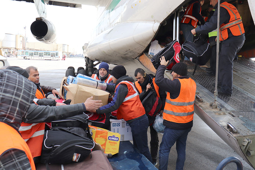 Men unload supplies from an Algerian plane at an airport, in Aleppo, Syria, February 7.. 