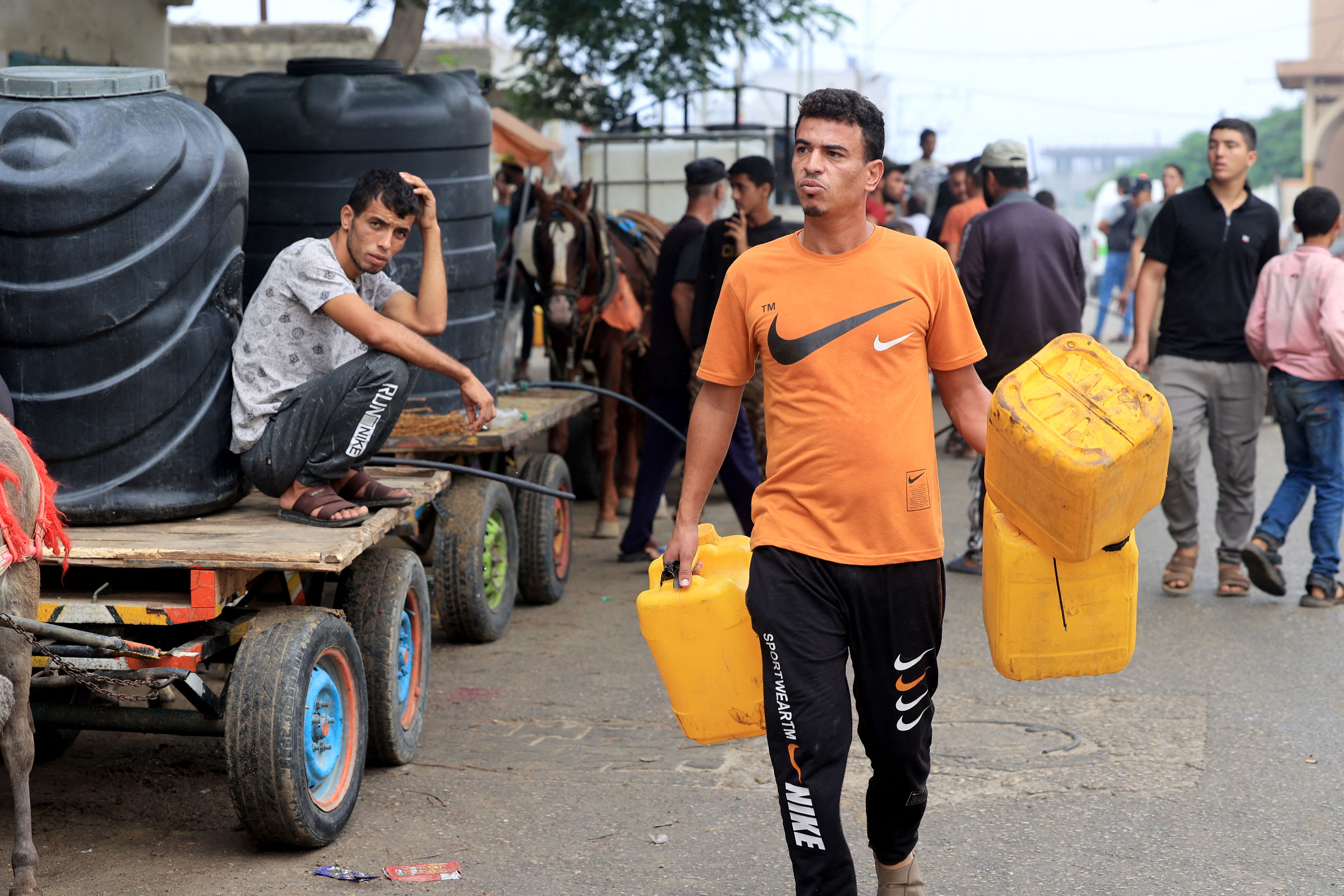 Palestinian civilians wait to collect water using horse- and donkey-drawn carts, in Rafah, southern Gaza, on October 28.