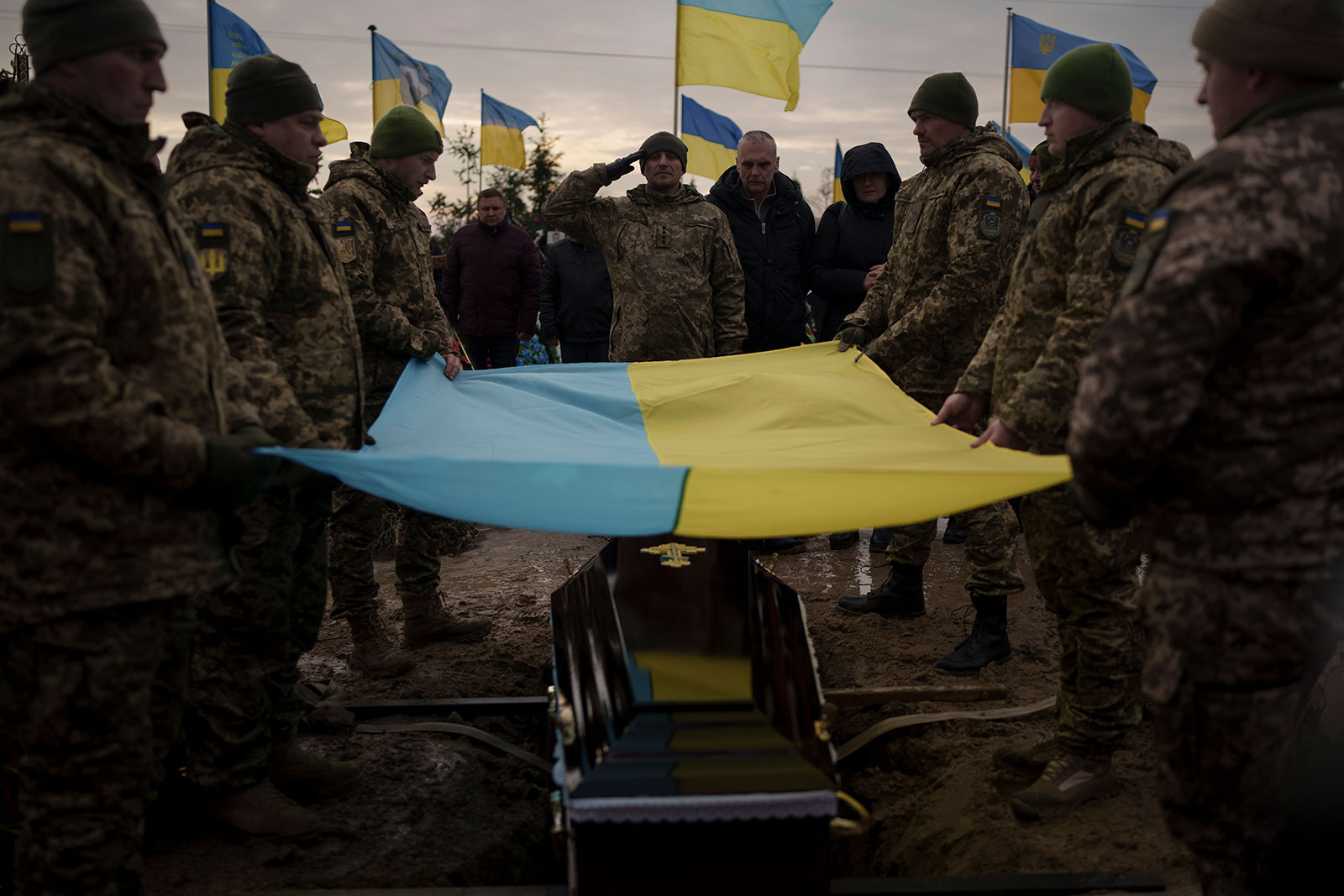Ukrainian soldiers hold their national flag over the coffin of comrade Dmytro Kyrychenko, during his funeral in Bucha, outskirts of Kyiv, Ukraine, on December 23. 