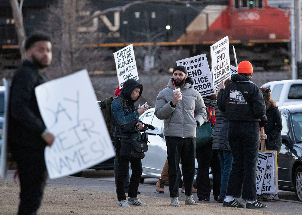 People hold signs during a protest in downtown Memphis Friday, January 27.