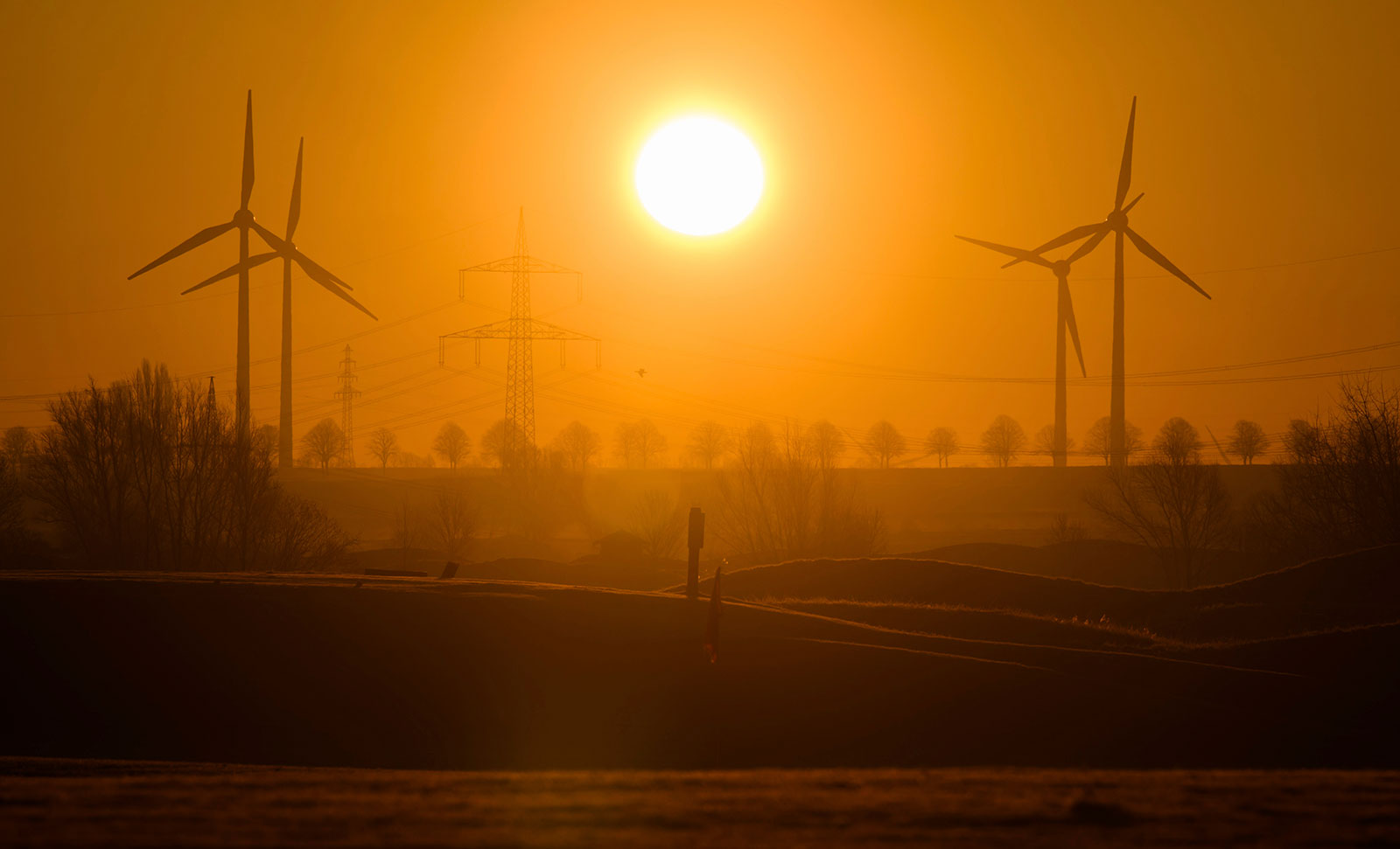 The sun rises between wind turbines and high voltage power lines in the Hannover region of Germany on March 8. 
