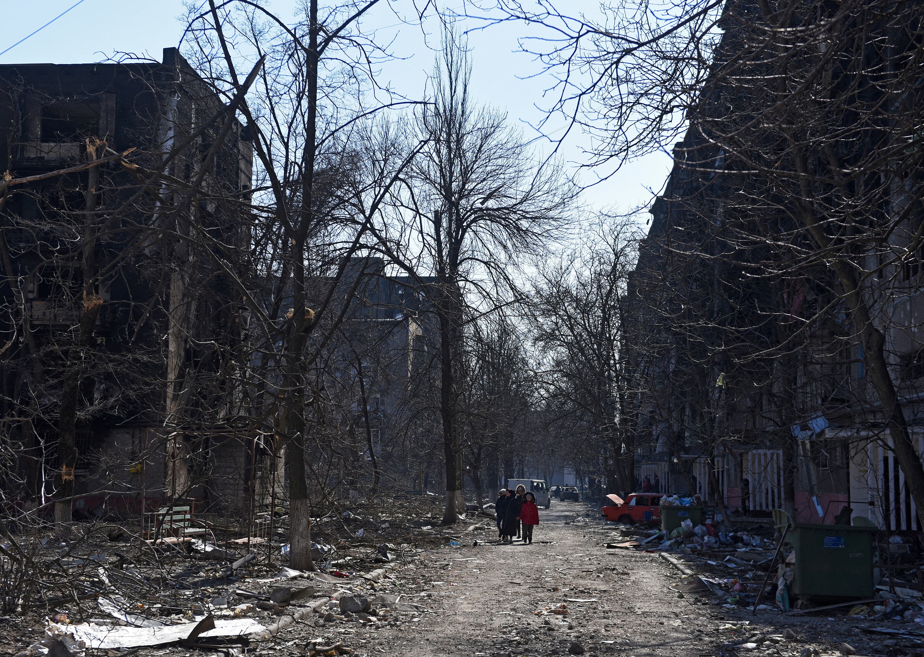 Residents walk past debris and damaged buildings in Mariupol, Ukraine on March 18. 