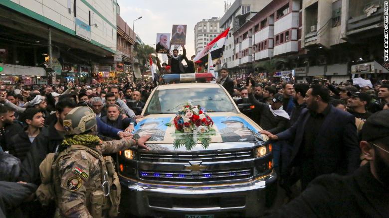 Mourners surround a car carrying Qasem Soleimani's coffin on Saturday in Baghdad.