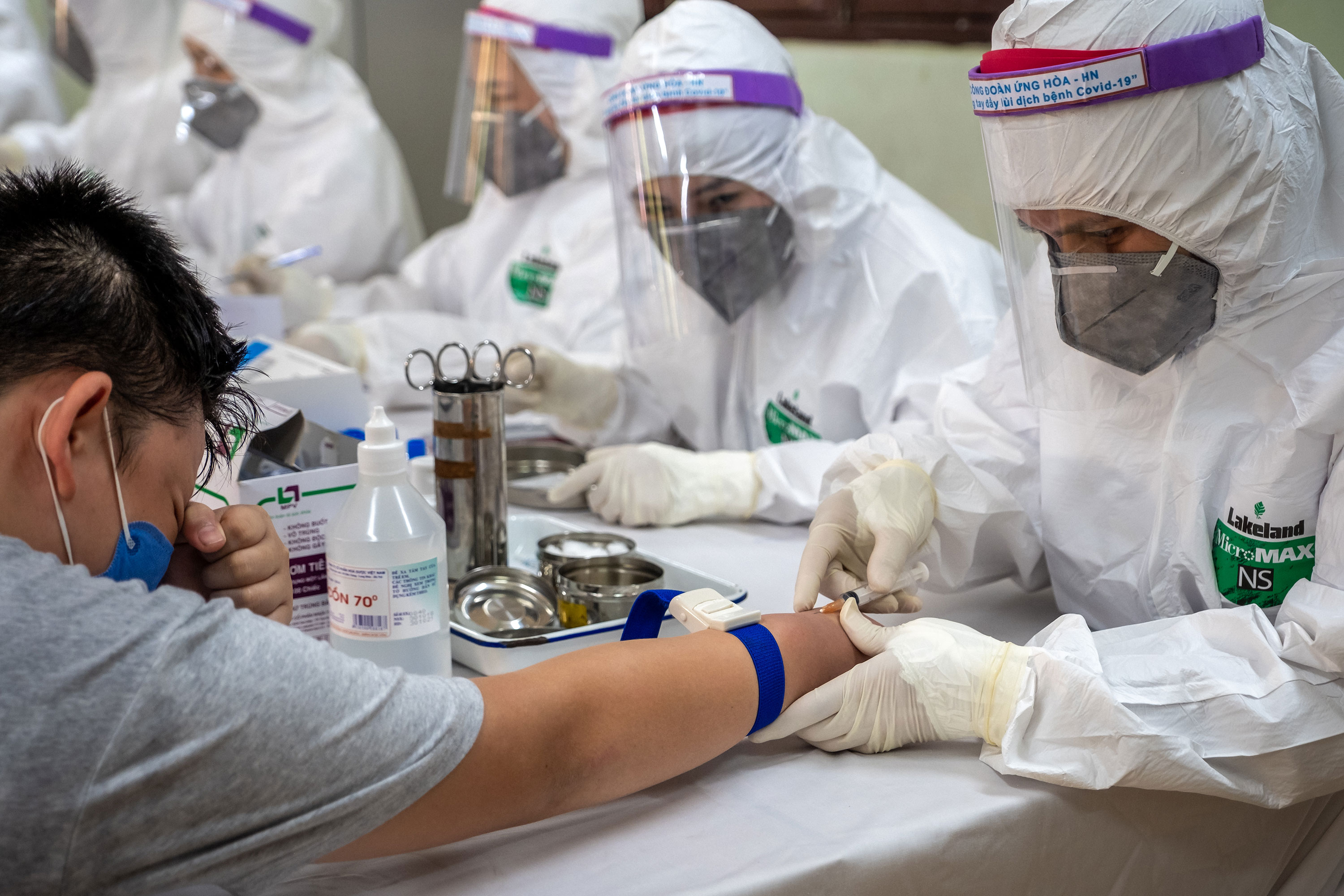Medical specialists collect blood samples for a coronavirus rapid test on July 31 in Hanoi, Vietnam.