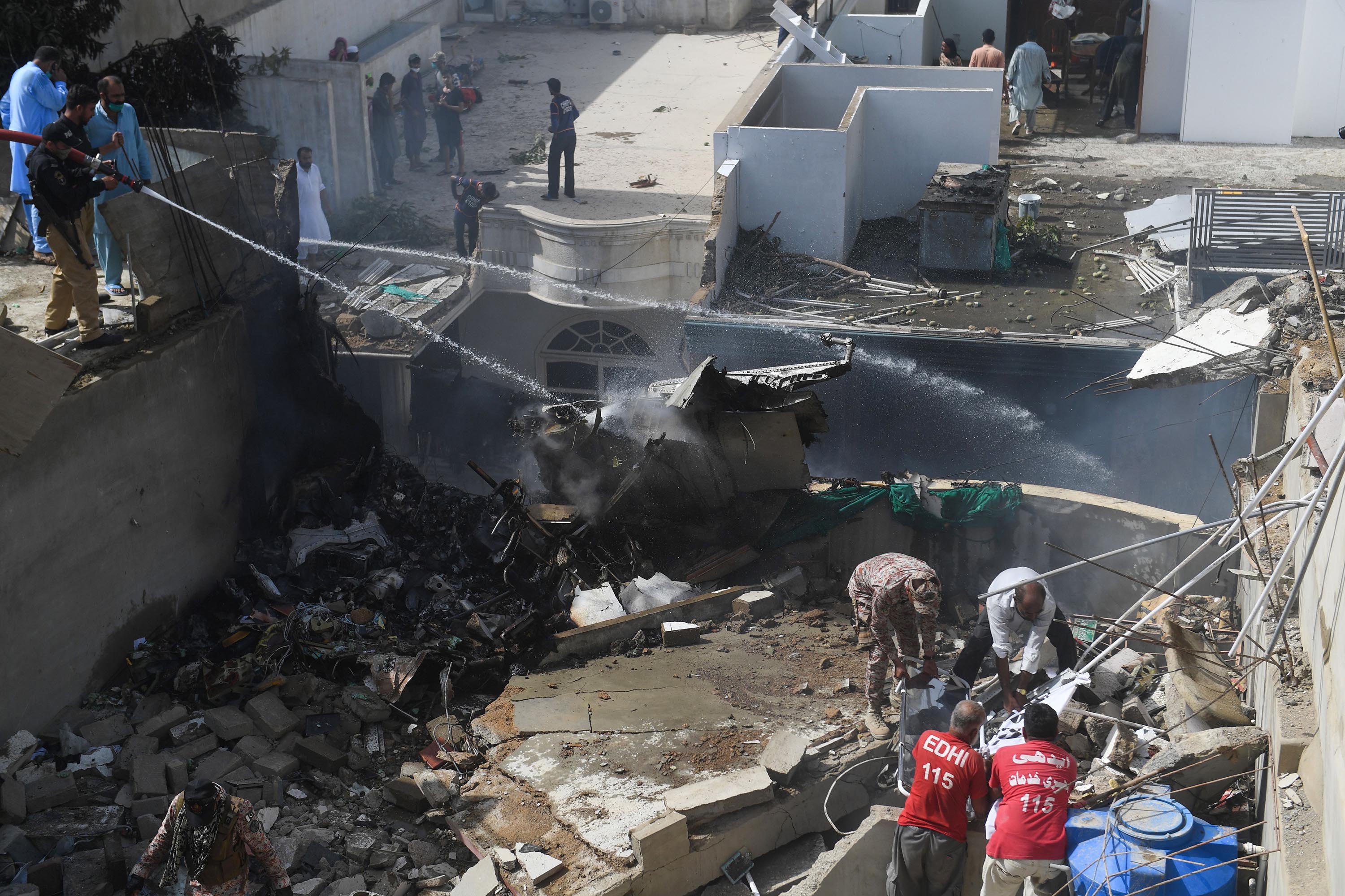 Emergency personnel work at the scene of the Pakistan International Airlines crash in Karachi on Friday.