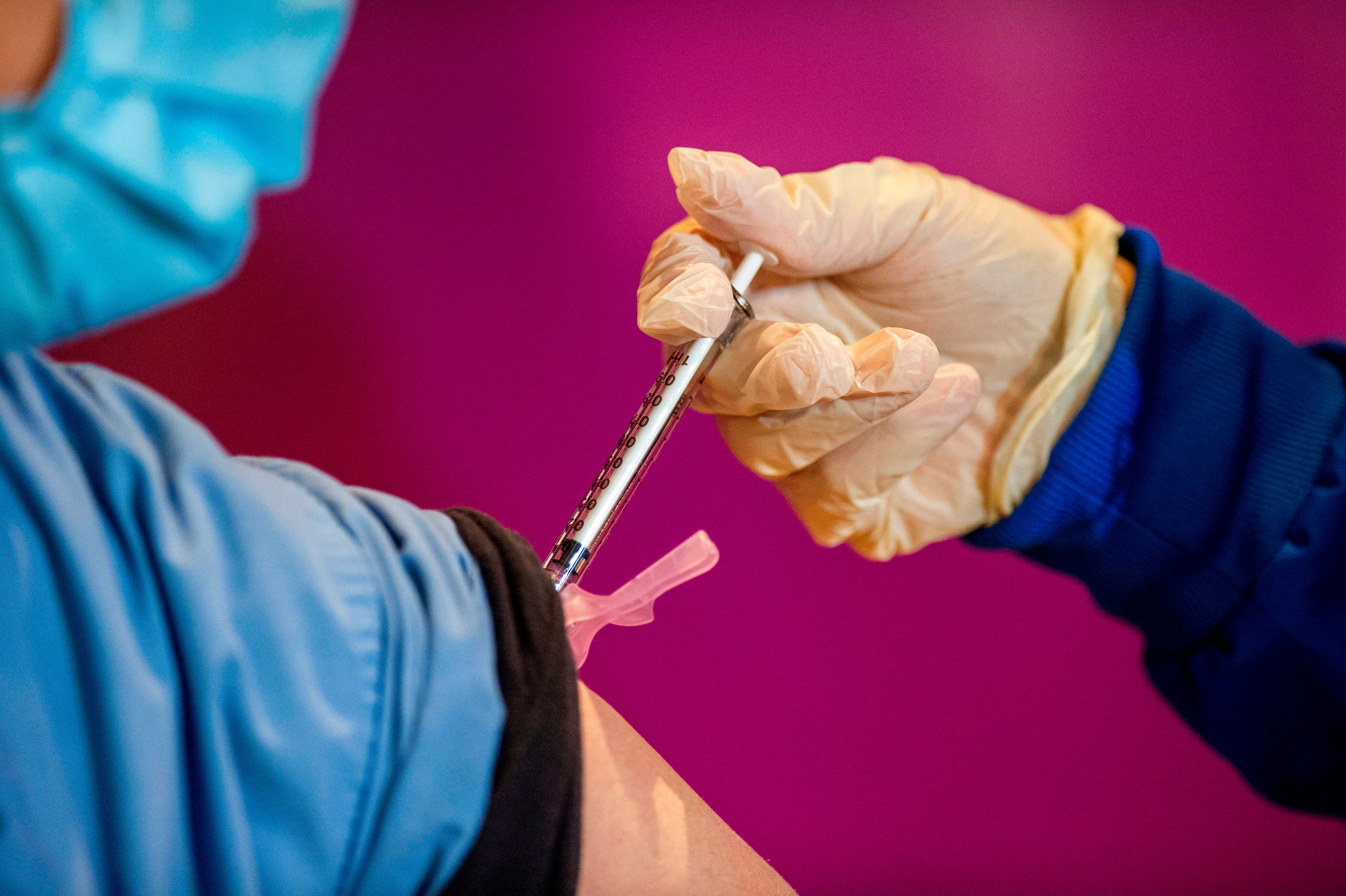 A registered nurse administers the second dose of the Pfizer/BioNTech Covid-19 vaccine to a health care worker in Hartford, Connecticut, on January 4.