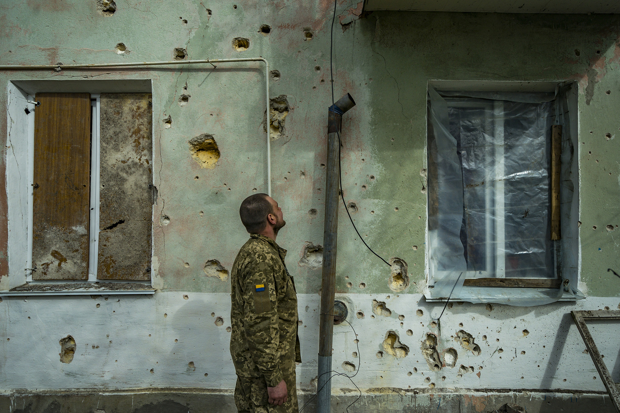 A Ukrainian soldier checks the shrapnel marks in a village near the frontline of Mykolaiv, Ukraine, on April 19.
