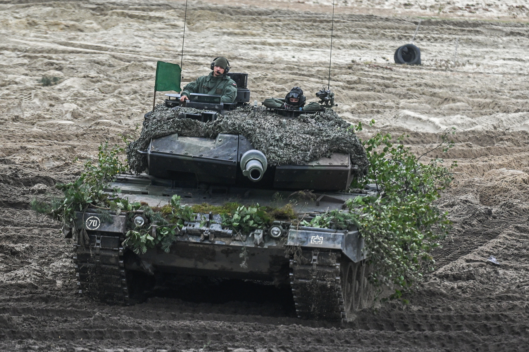 Poolse militairen besturen een Leopard-tank tijdens een live vuurdemonstratie als onderdeel van de militaire oefeningen van Bear 22 op het oefenterrein van Nowa Deba op 21 september in Nowa Deba, Polen. 