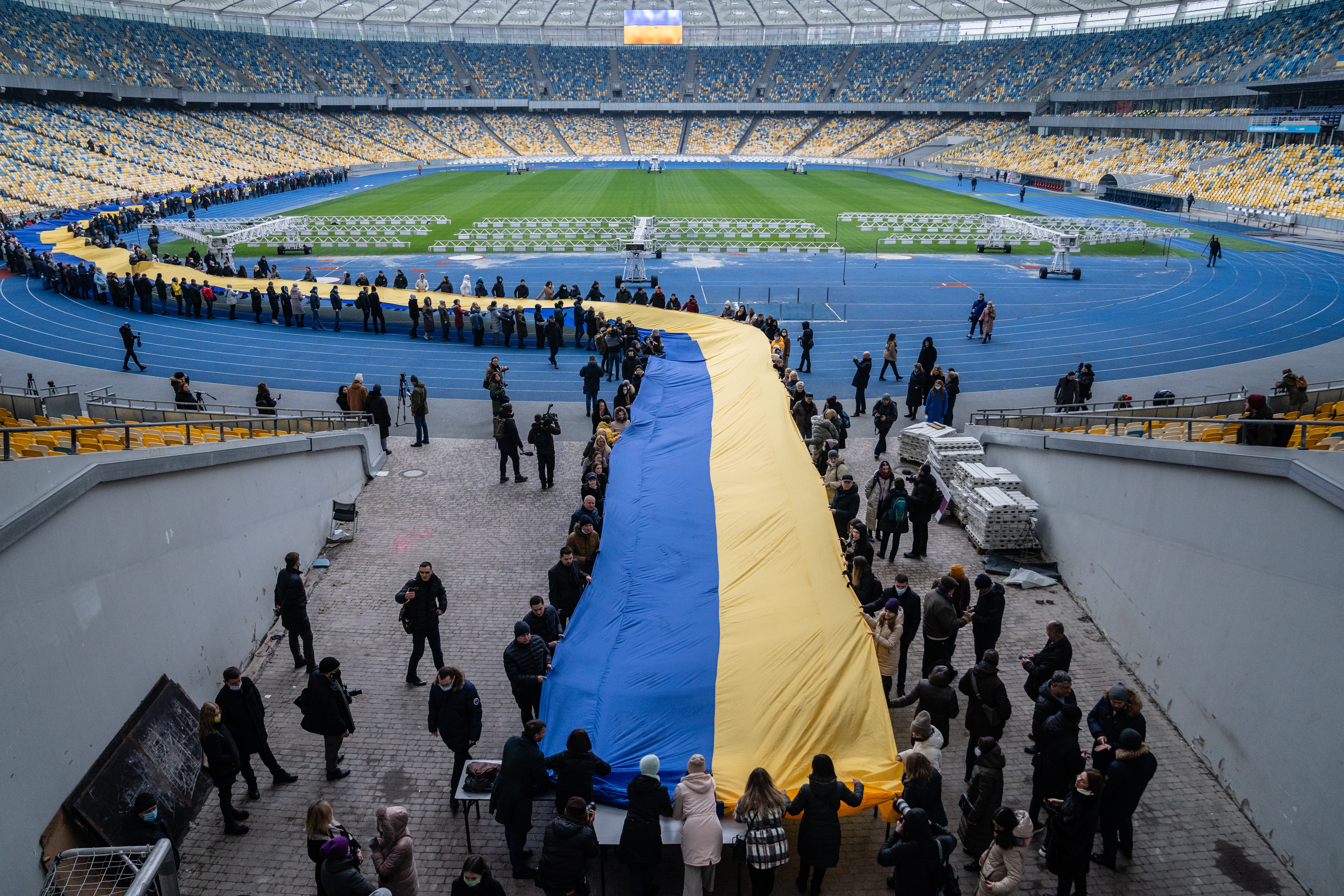 People carry a 200 meter-long Ukrainian flag at the Olympic stadium to mark a "Day of Unity" in Kyiv on February 16.