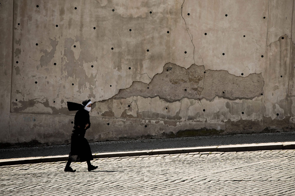 A nun wearing a face mask walks on the street on April 5, in Prague, where most activities slowed down or came to a halt due to the spread of the coronavirus.
