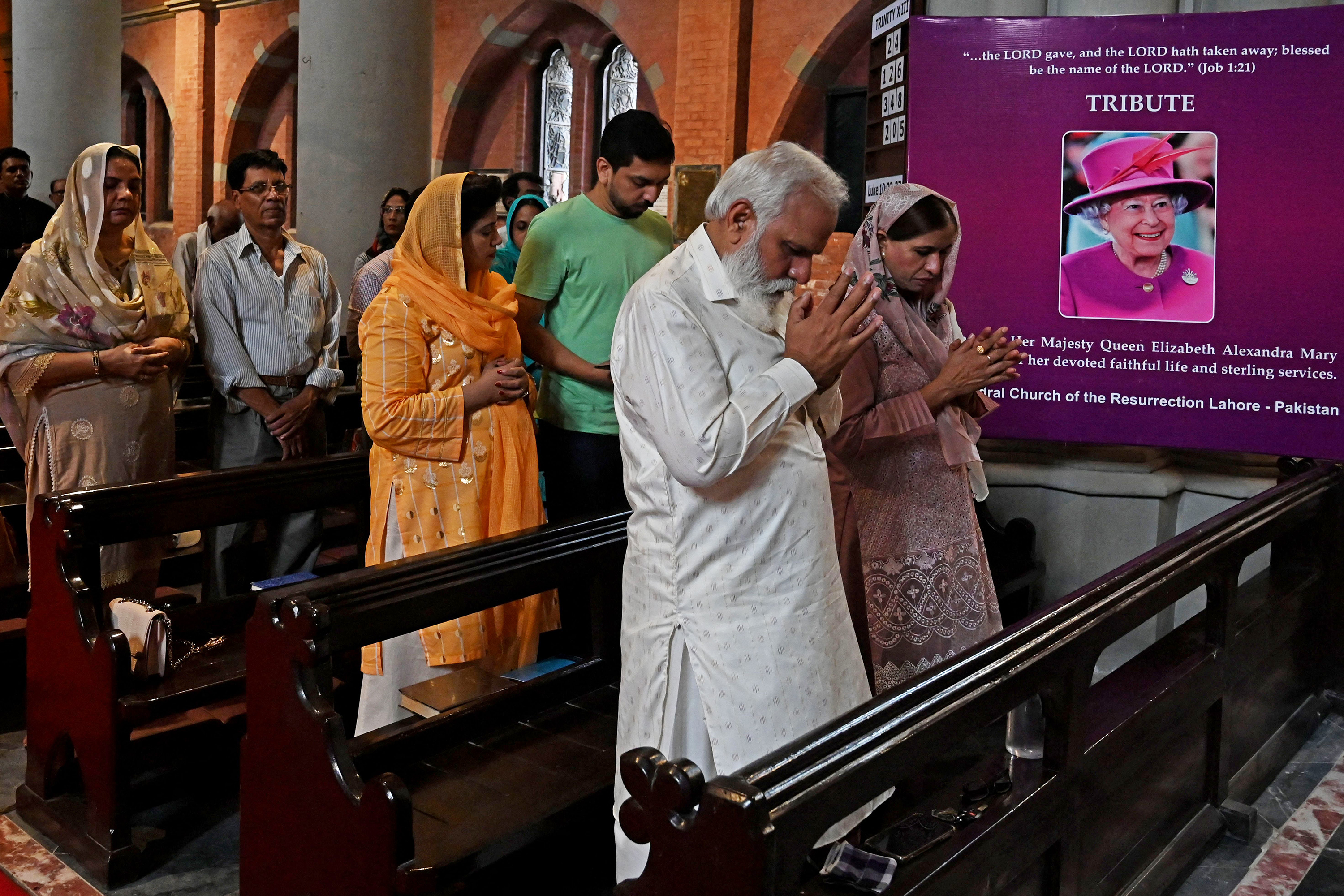 People pray for late Britain's Queen Elizabeth II in Pakistan on September 11.