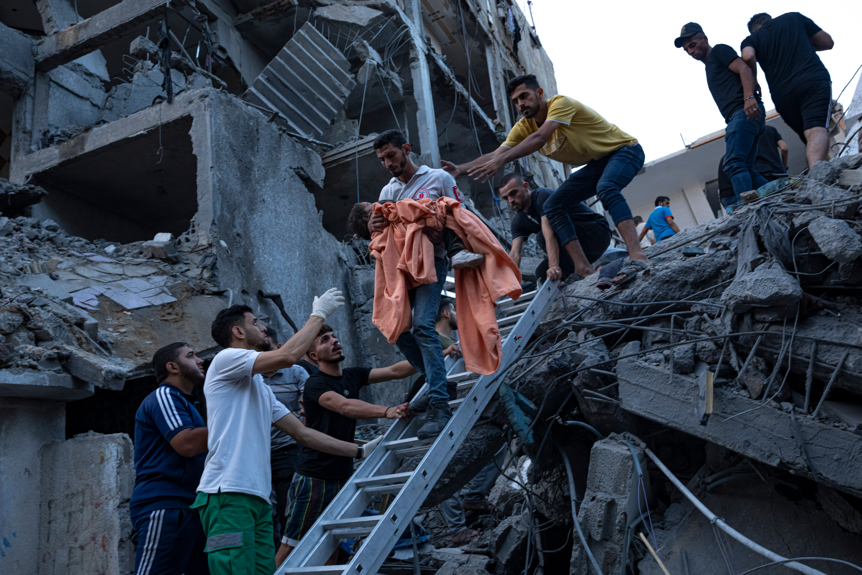 Palestinians rescue a young girl from the rubble of a destroyed residential building, following an Israeli airstrike, on October 10, 2023.