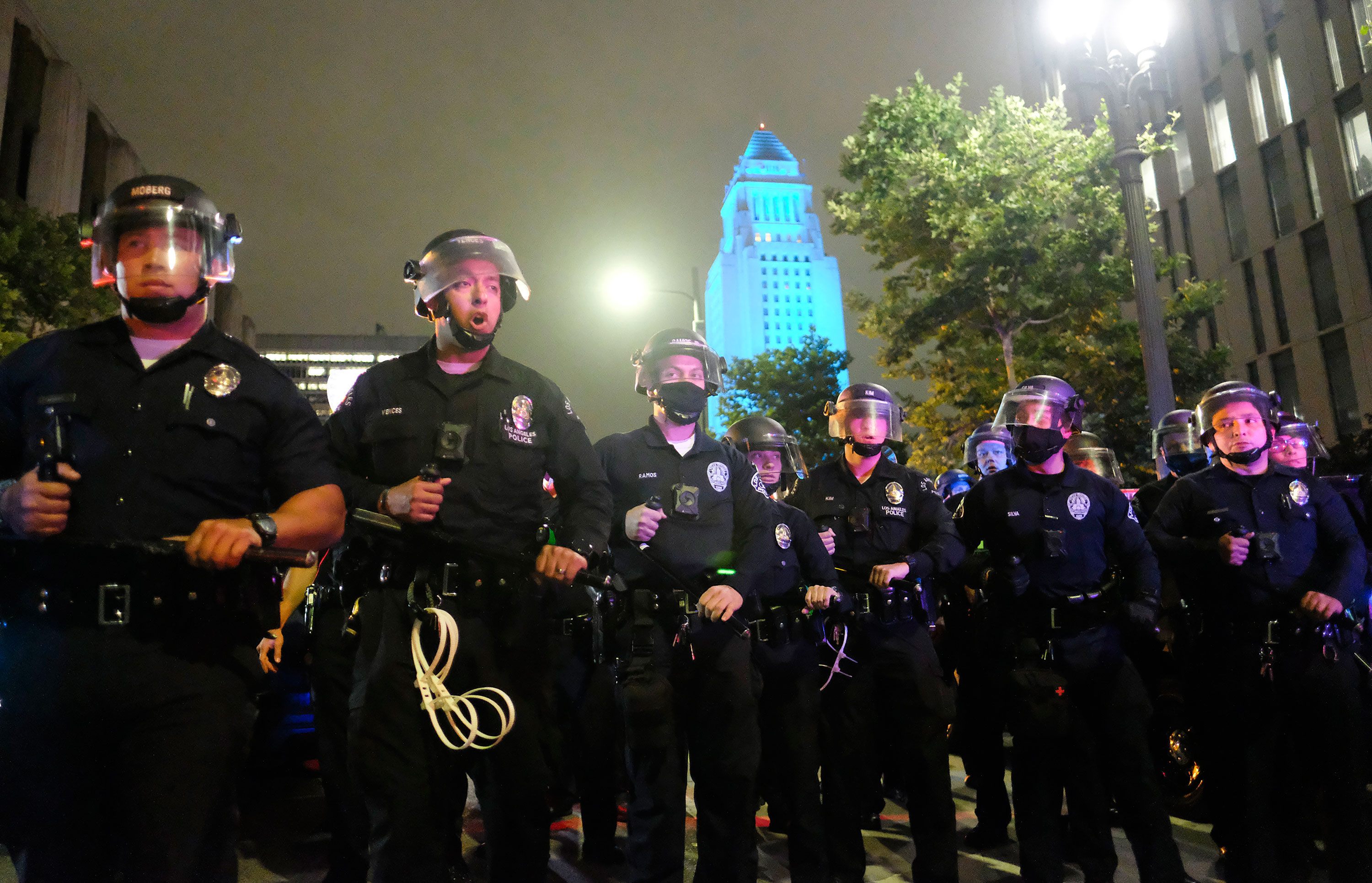 Police officers stand guard near City Hall during a protest over the death of George Floyd on Friday night in Los Angeles. 