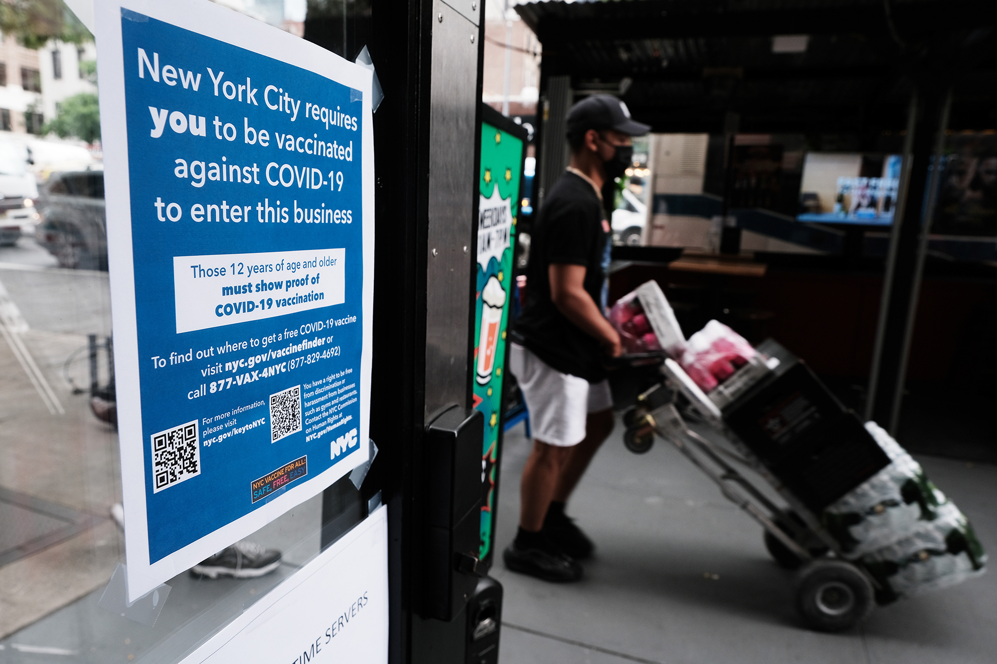 A sign in a restaurant window informs customers that they will need to show proof that they are at least partly vaccinated for Covid-19 to be allowed in the business on August 20, 2021 in New York City. New York City has begun checking people’s vaccination status at museums, gym’s, restaurants and other public establishments as it becomes the nation’s largest city to exclude the unvaccinated from public places. 