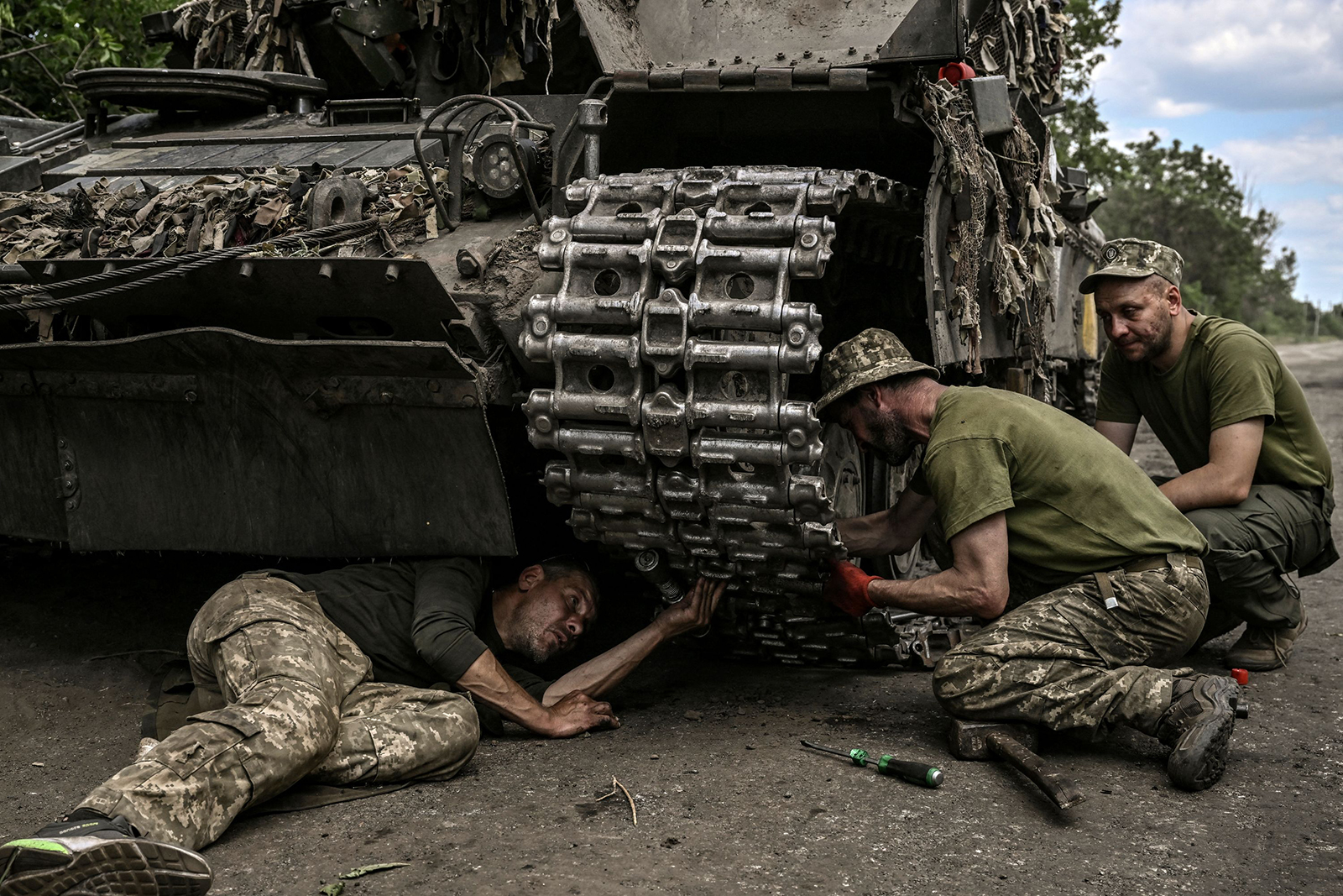 Ukrainian troop members repair an army's Main Battle Tank (MBT) in the eastern Ukrainian region of Donbas on June 7.