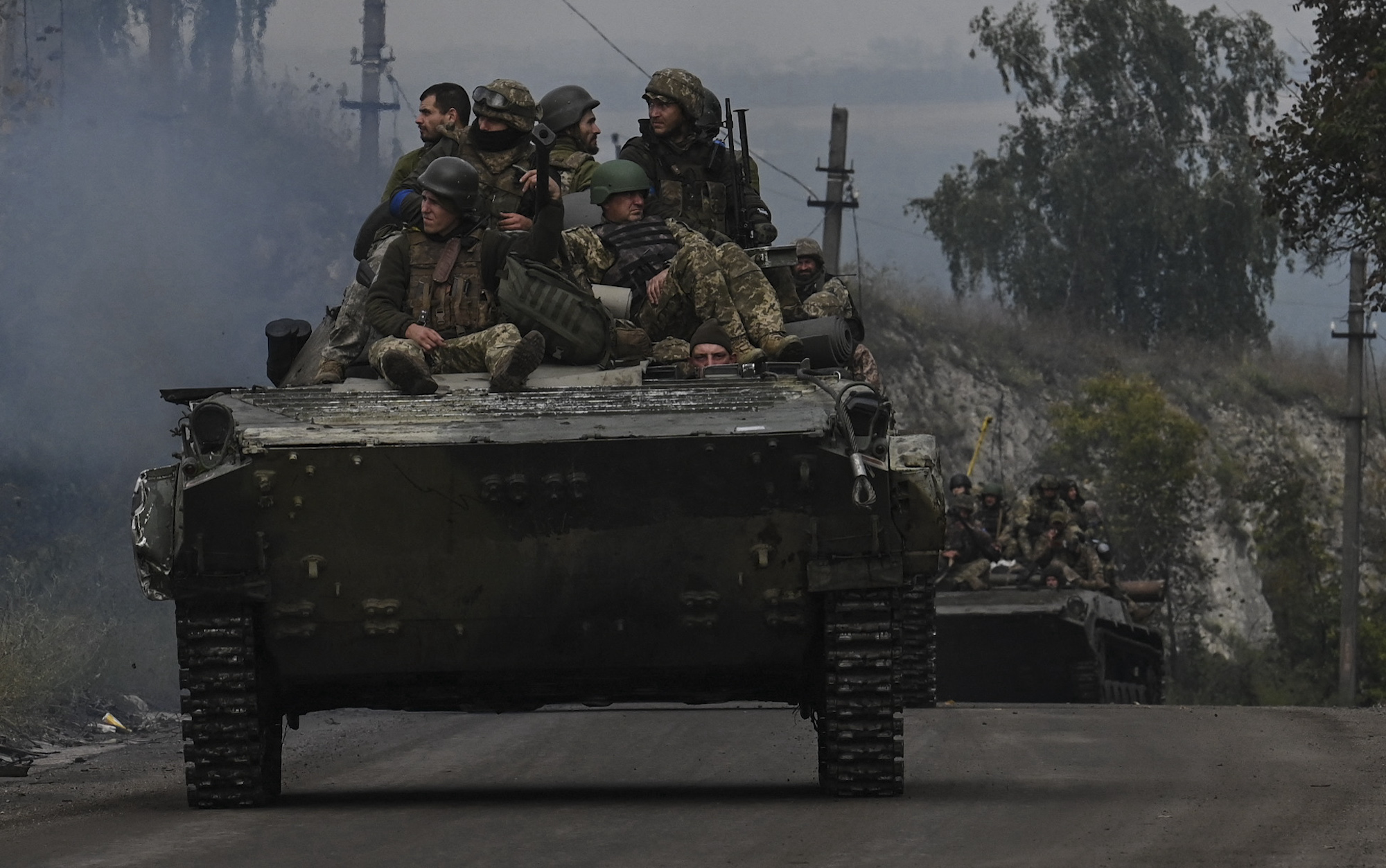 Ukrainian soldiers sit on infantry vehicles as they drive near Izium in Kharkiv Oblast on September 16.