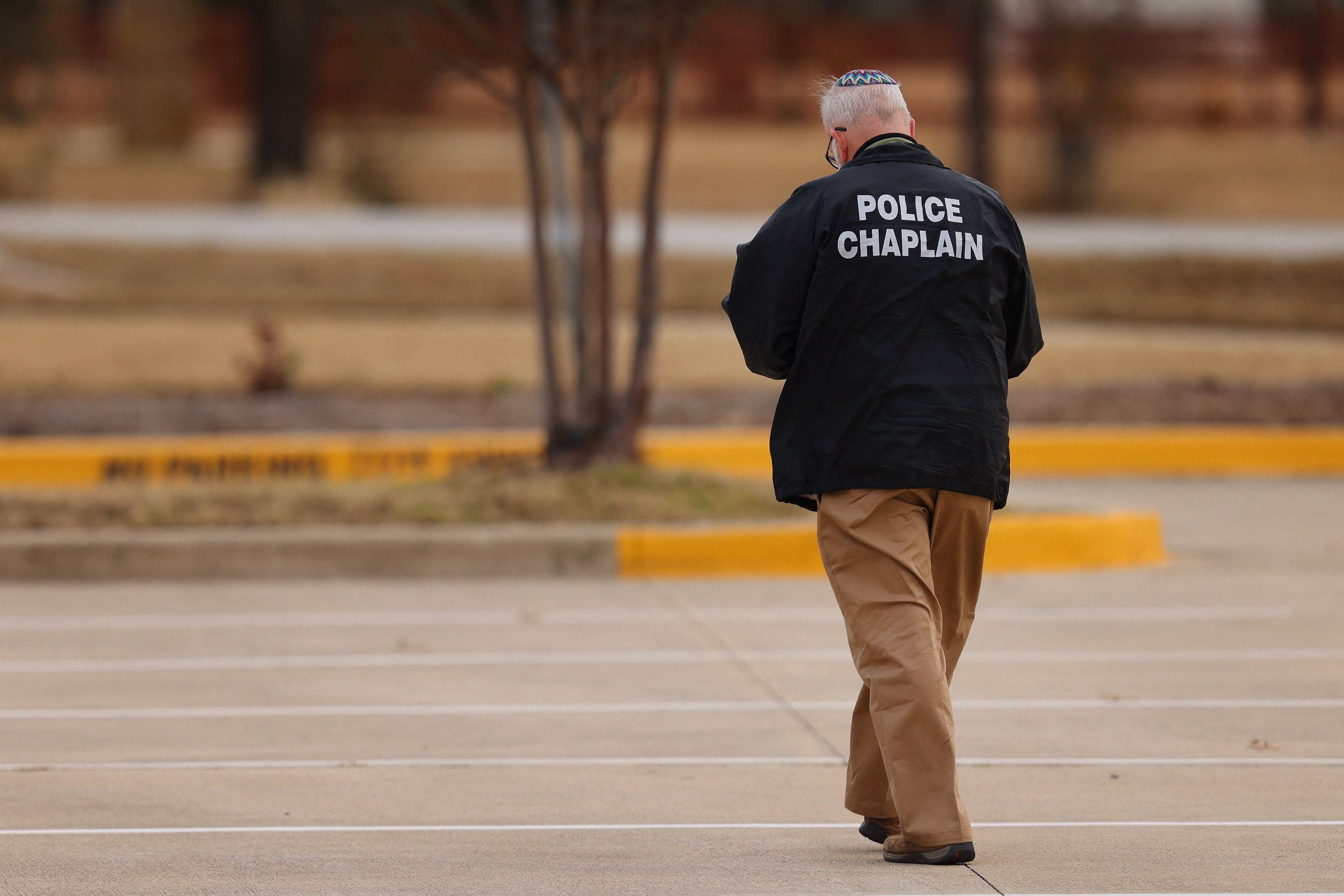 A police chaplain walks near the Congregation Beth Israel Synagogue in Colleyville, Texas, on Saturday. 