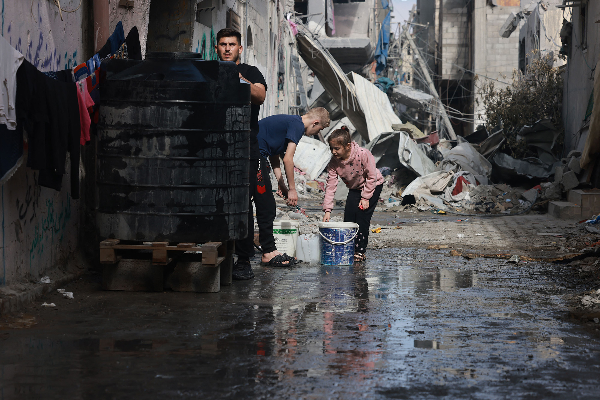 Palestinian children fill containers with water in Bureij, Gaza, on November 14.