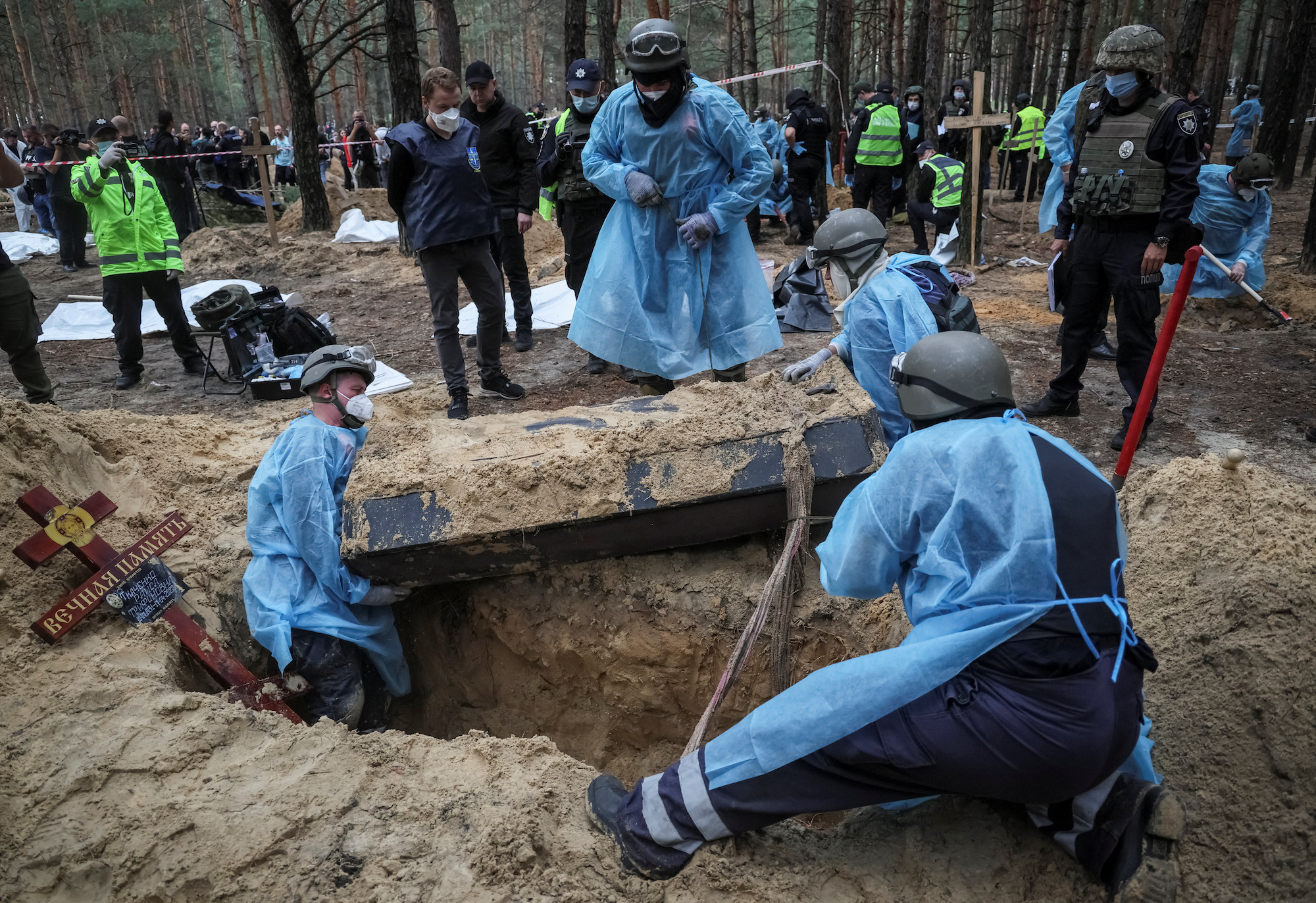 Members of the Ukrainian Emergency Service work on an exhumation of a mass burial site in the town of Izium, Kharkiv region on September 16.