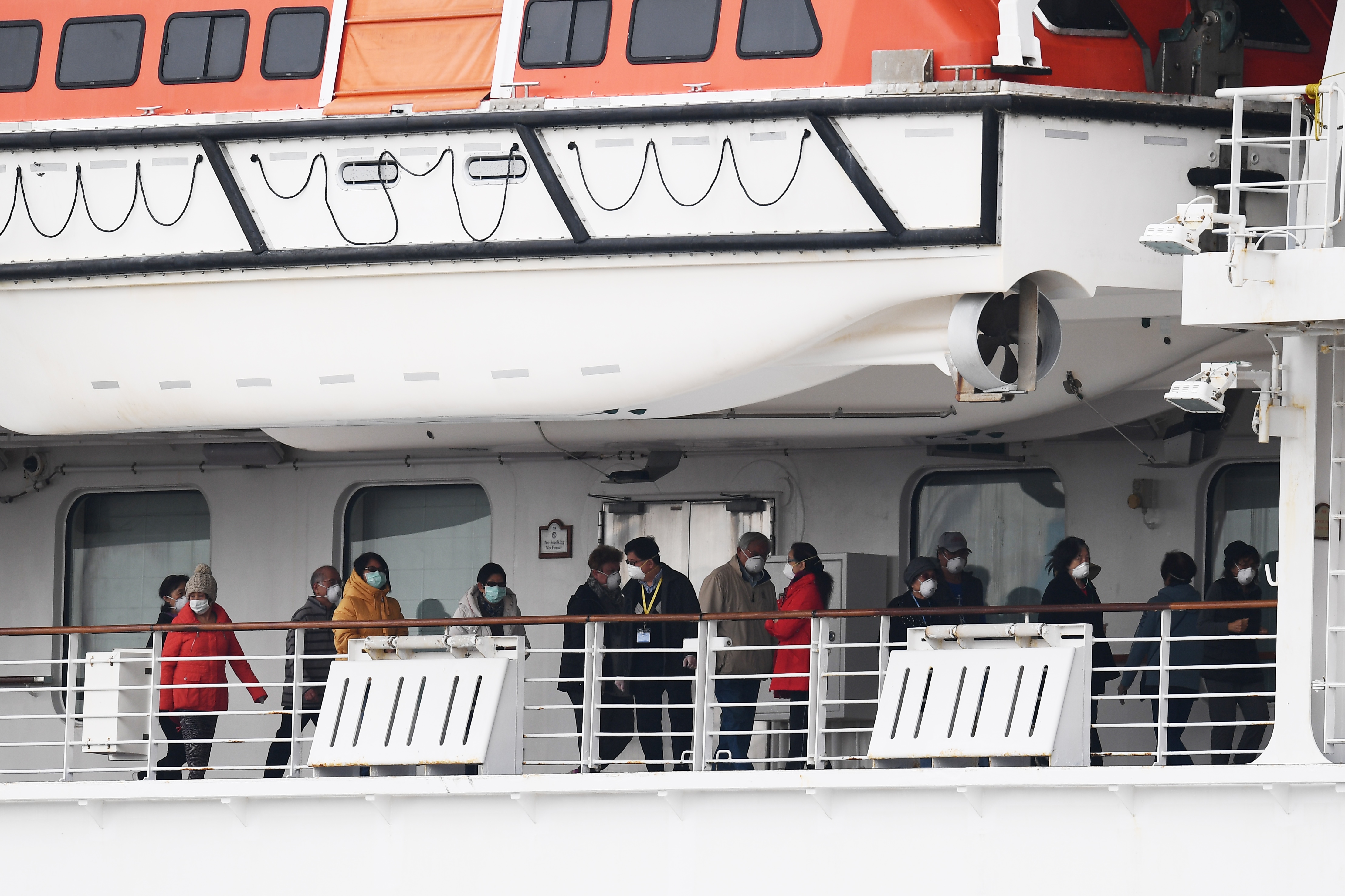 Passengers walk along the deck of the Diamond Princess cruise ship, docked in Yokohama, Japan, on February 14, 2020.
