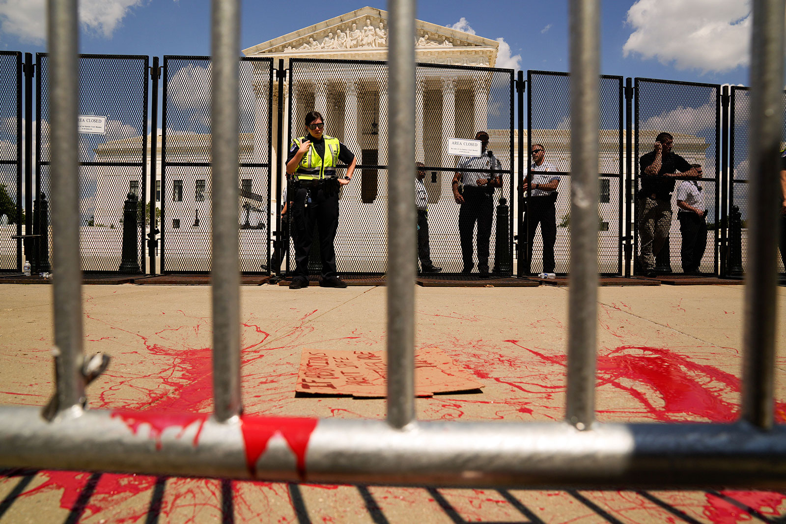 US Capitol Police officers stand in front of an abandoned sign and paint splatter outside the Supreme Court on Saturday. 