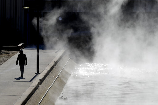 A pedestrian walks along the Canal Walk downtown in Indianapolis on Wednesday as temperatures remained below zero in Central Indiana. 