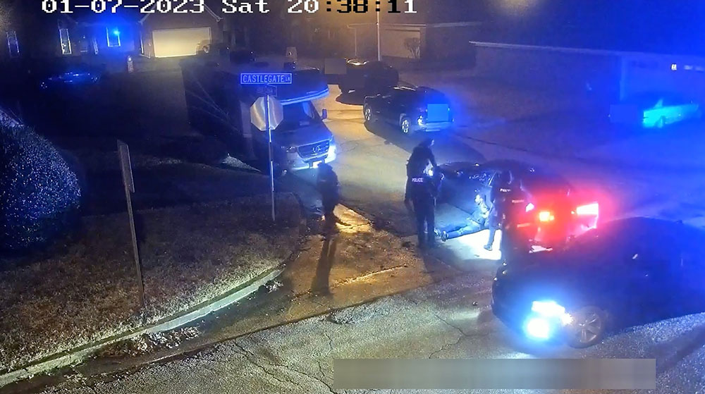 Tyre Nichols is seen leaning against a police car.