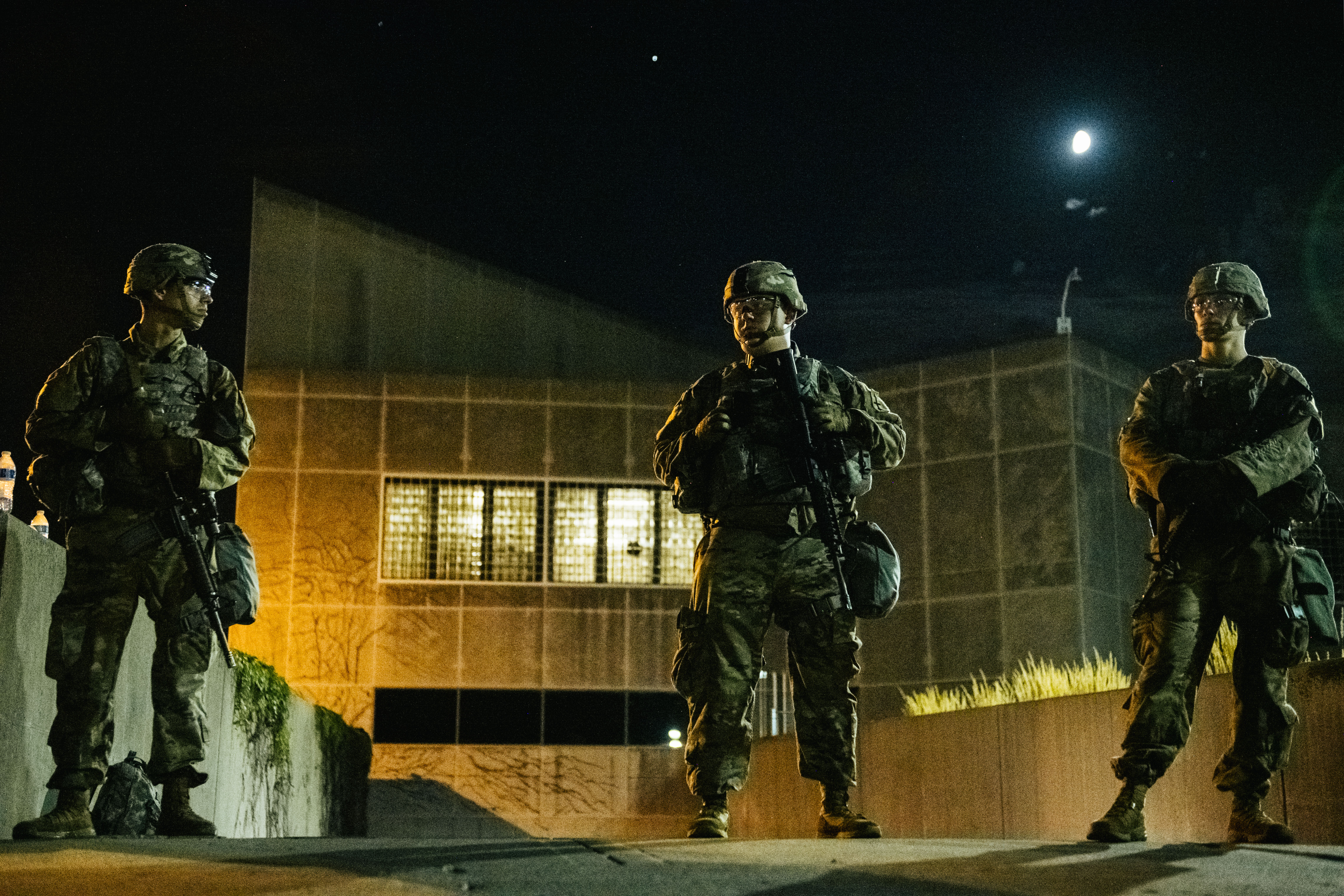 Members of the National Guard stand inside a fenced area surrounding government buildings in Kenosha, Wisconsin, on August 27.